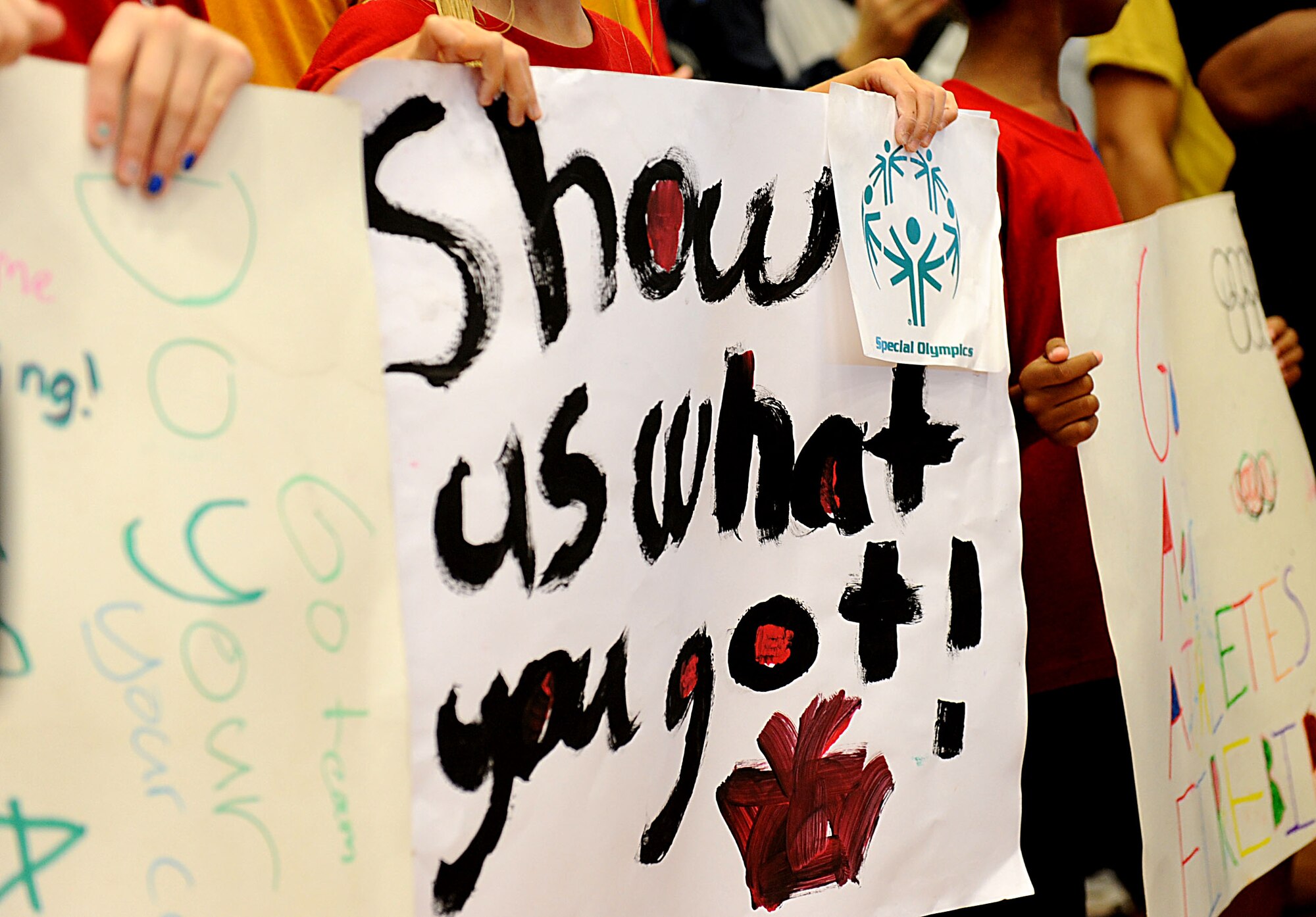 Amelia Earhart Intermediate School cheerleaders hold signs in support of Kadena Special Olympics athletes on Kadena Air Base, Japan, Nov. 5, 2011. The KSO is a one-day sporting and entertainment event with more than 870 special needs athletes and artists participating in a day of competition, music and special recognition. (U.S. Air Force photo/Airman 1st Class Brooke P. Beers/released)