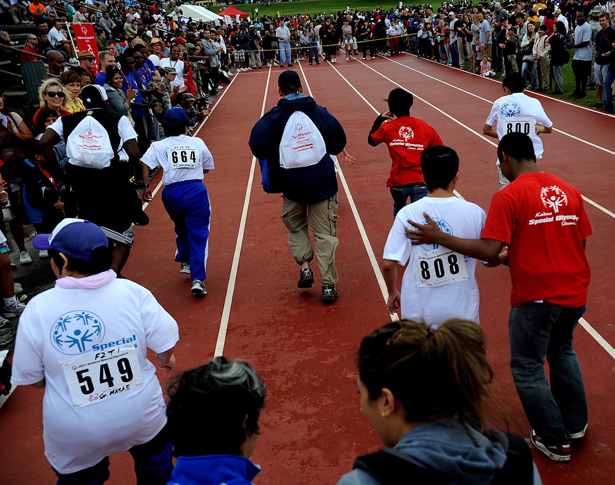 Japanese athletes and their helpers run the 30m dash during the Kadena Special Olympics, Nov. 5, 2011 on Kadena Air Base, Japan. This year marks the 12th annual KSO, a sporting event dedicated to enriching the lives of special-needs individuals while strengthening U.S.-Okinawa relationships.(U.S. Air Force photo/Staff Sgt. Christopher Hummel/released)