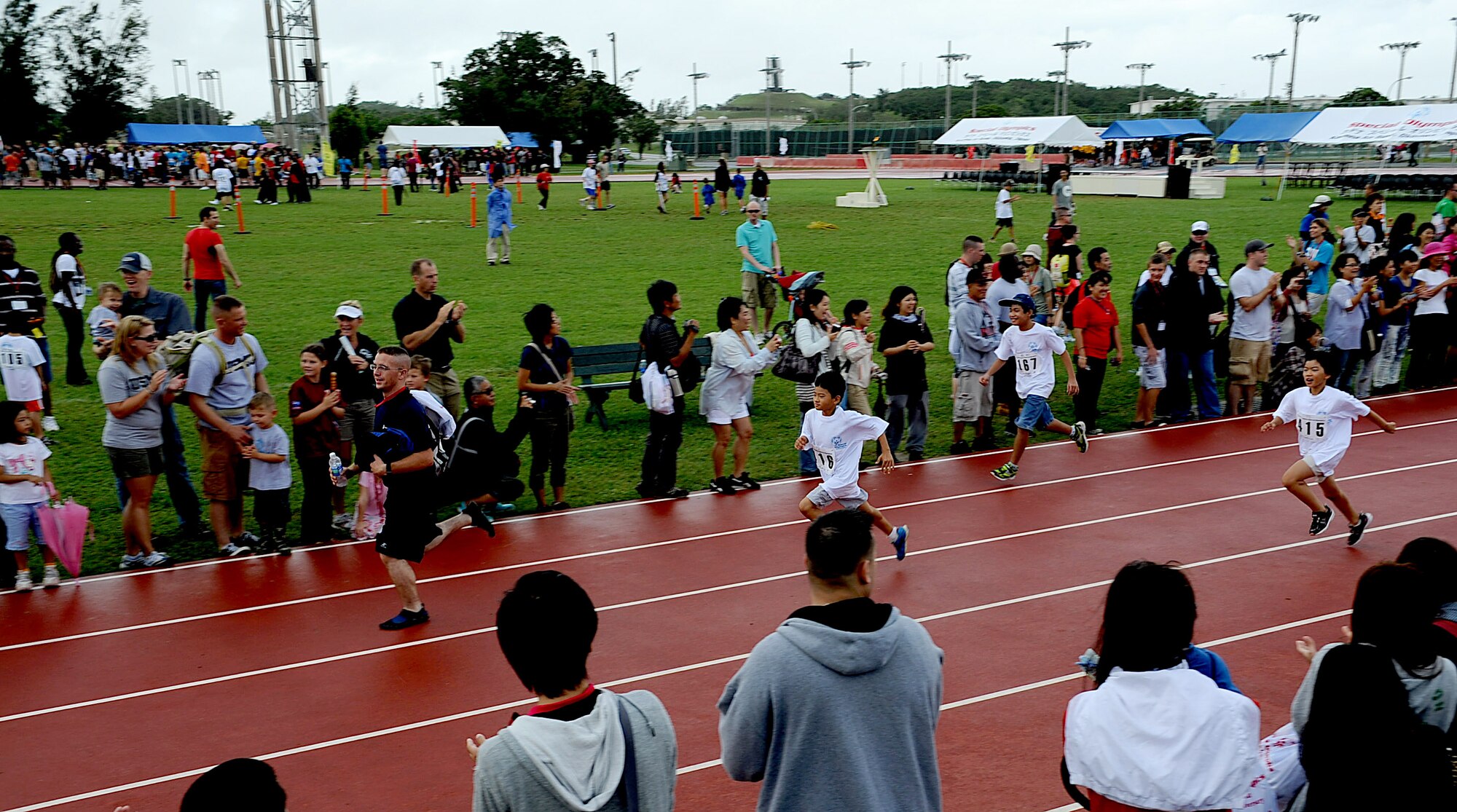 Japanese athletes and their helpers run the 30m dash during the Kadena Special Olympics, Nov. 5, 2011 on Kadena Air Base, Japan. This year marks the 12th annual KSO, a sporting event dedicated to enriching the lives of special-needs individuals while strengthening U.S.-Okinawa relationships.(U.S. Air Force photo/Staff Sgt. Christopher Hummel/released)