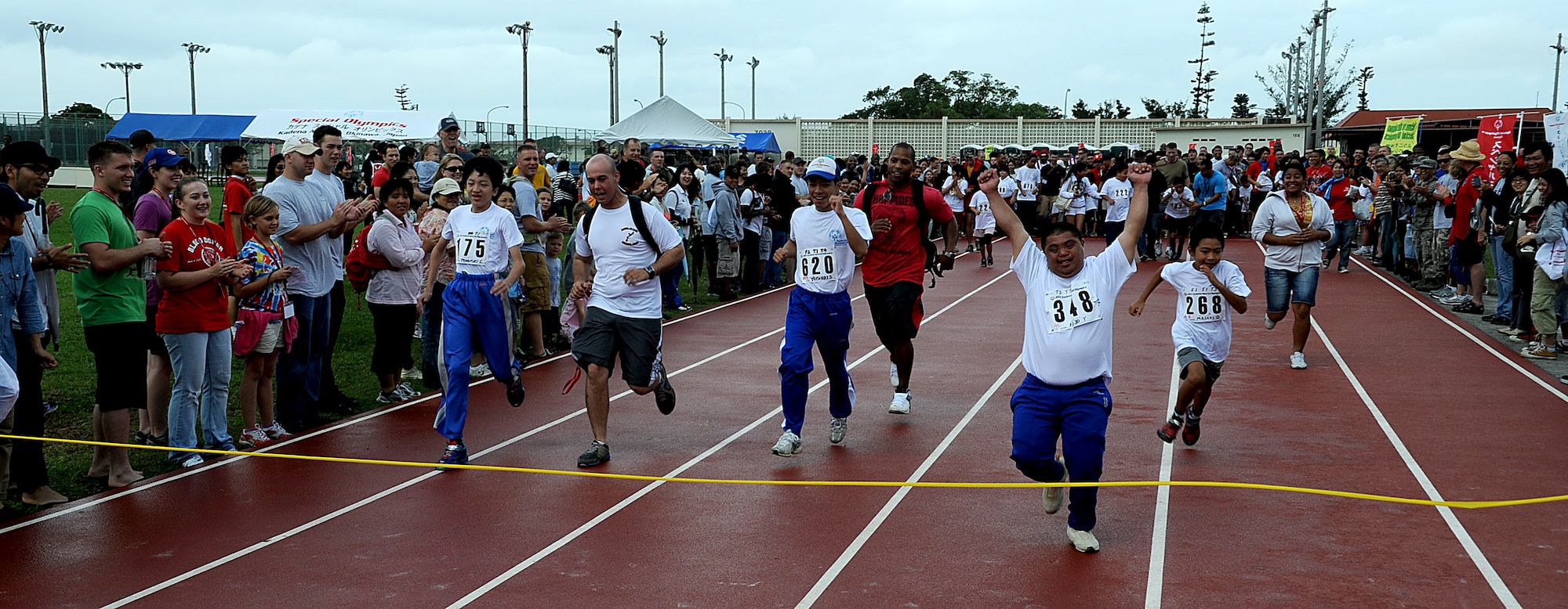 Japanese athletes and their helpers run the 30m dash during the Kadena Special Olympics, Nov. 5, 2011, Kadena Air Base, Japan. This year marks the 12th annual KSO, a sporting event dedicated to enriching the lives of special-needs individuals while strengthening U.S.-Okinawa relationships.(U.S. Air Force photo/Staff Sgt. Christopher Hummel/released)