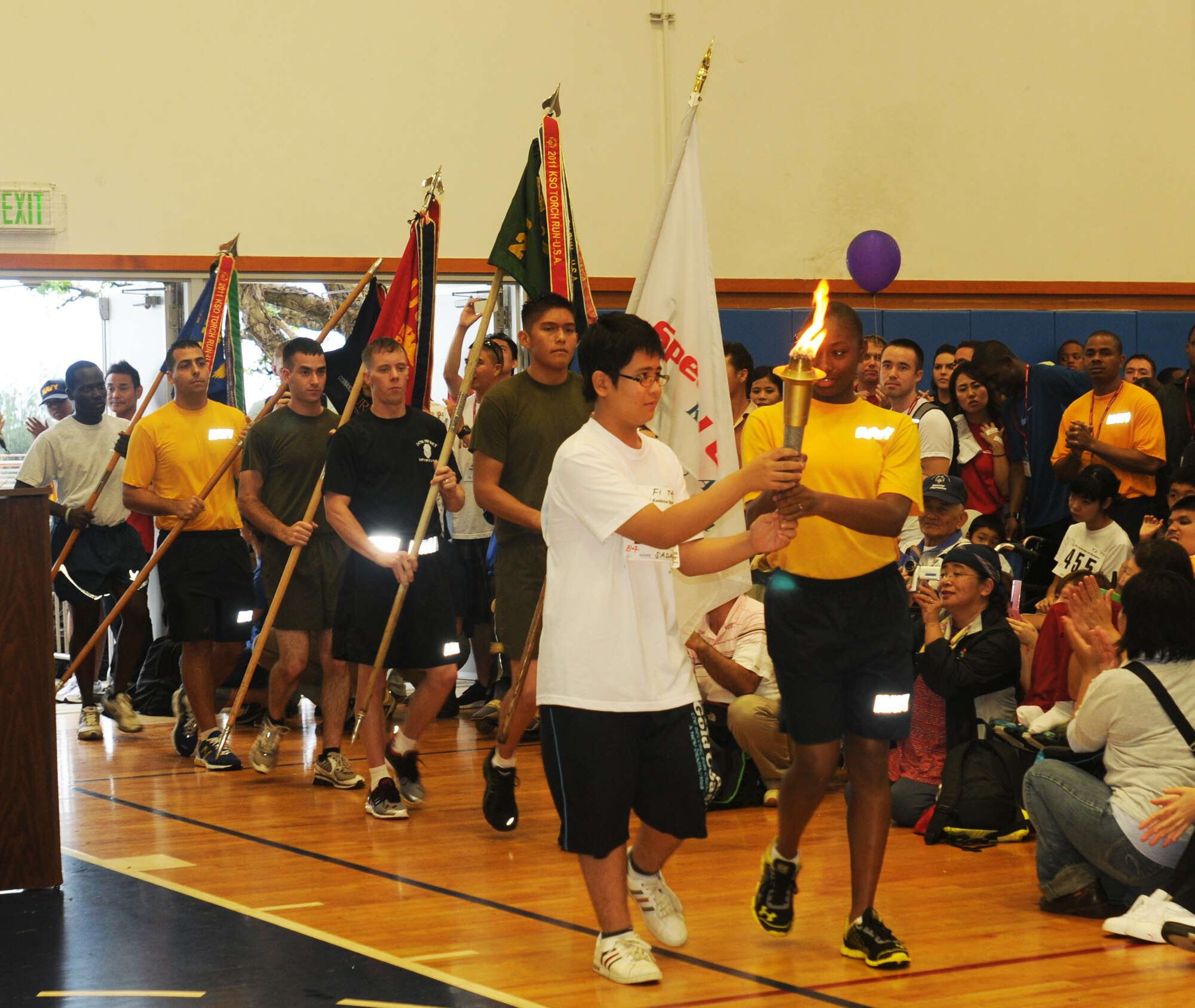 Sadamu Malamute, Kadena Special Olympics athlete, and Master at Arms Seaman Mieshia Sledge bring in the KSO torch officially opening the 12th annual KSO on Kadena Air Base, Japan, Nov. 5, 2011. The KSO is a one-day sporting and entertainment event with more than 870 special needs athletes and artists participating in a day of competition, music and special recognition. (U.S. Air Force photo/Tech. Sgt. Amanda Savannah/released)