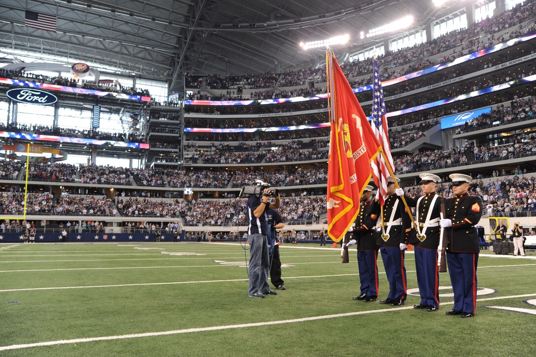 The color guard assigned to the 8th Marine Corps District stand at "present arms" during the playing of the National Anthem at Cowboys Stadium, Arlington, Texas, Jan. 6, 2011. The color guard consists of two rifle barriers, one color sergeant, and one flag barrier. (U.S.  Marine Corps photo by Lance Cpl. Alfredo V. Ferrer)