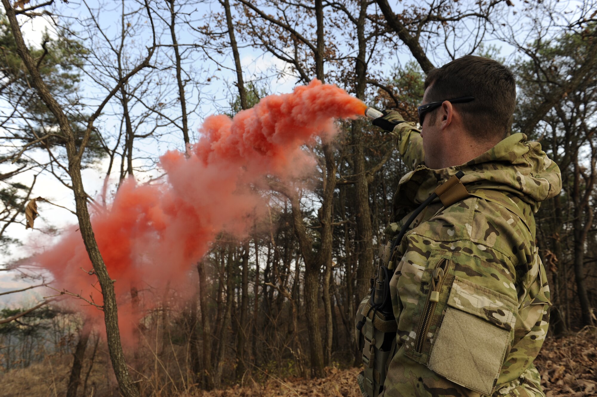 U.S. Air Force Staff Sgt. Robert Colliton, Survival Evasion Resistance Escape specialist from the 18th Operation Support Squadron on Kadena Air Base, Japan, pops smoke as a signal to rescue aircraft so they can pinpoint his location during exercise PACIFIC THUNDER Nov. 3 near Osan Air Base, Republic of Korea.
PACIFIC THUNDER is a 10-day exercise from Oct. 31 to Nov. 9 at Osan AB. The exercise involves the 33rd Rescue Squadron from Kadena AB, Japan, and the 25th Fighter Squadron from Osan. These units work together to practice combat search and rescue tactics to prepare for real-world emergency situations. (U.S. Air Force photo/Tech. Sgt. Angelique Bilog/released)

