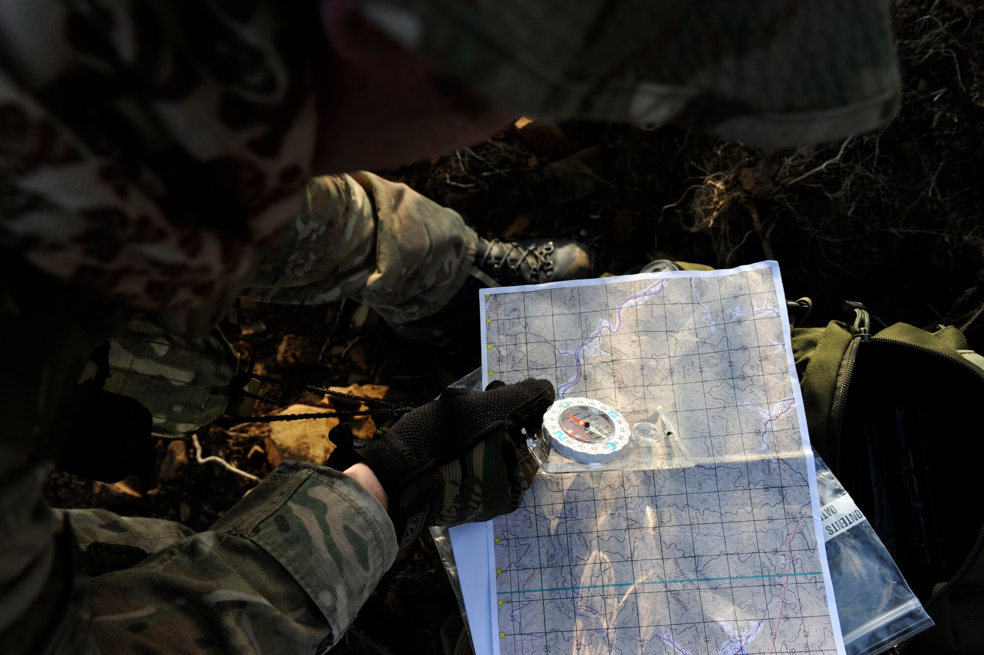 U.S. Air Force Staff Sgt. Robert Colliton, Survival Evasion Resistance Escape specialist from the 18th Operation Support Squadron on Kadena Air Base, Japan, checks his coordinates on a map before heading out to the helicopter pick-up point during exercise PACIFIC THUNDER Nov. 3 near Osan Air Base, Republic of Korea.
PACIFIC THUNDER is a 10-day exercise from Oct. 31 to Nov. 9 at Osan AB. The exercise involves the 33rd Rescue Squadron from Kadena AB, Japan, and the 25th Fighter Squadron from Osan. These units work together to practice combat search and rescue tactics to prepare for real-world emergency situations. (U.S. Air Force photo/Tech. Sgt. Angelique Bilog/released)
