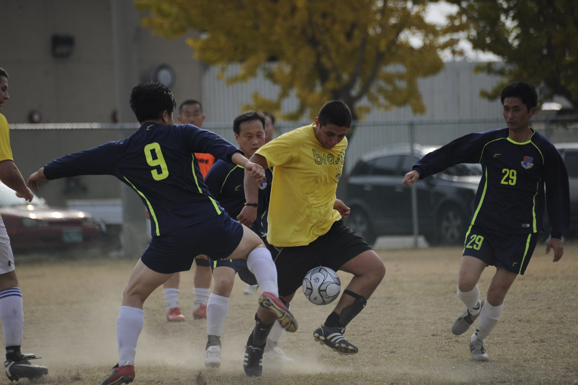 Senior Airman Mauricio Murcia, 80th Fighter Squadron aviation resource manager, kicks the soccer ball through Korean Union team defenders at a soccer event during the Korean-American Sports Day at Kunsan Air Base, Republic of Korea, Nov. 2, 2011. The day had various events including soccer, tug-of-war and paintball. (U.S. Air Force photo by Staff Sgt. Rasheen Douglas/Released)