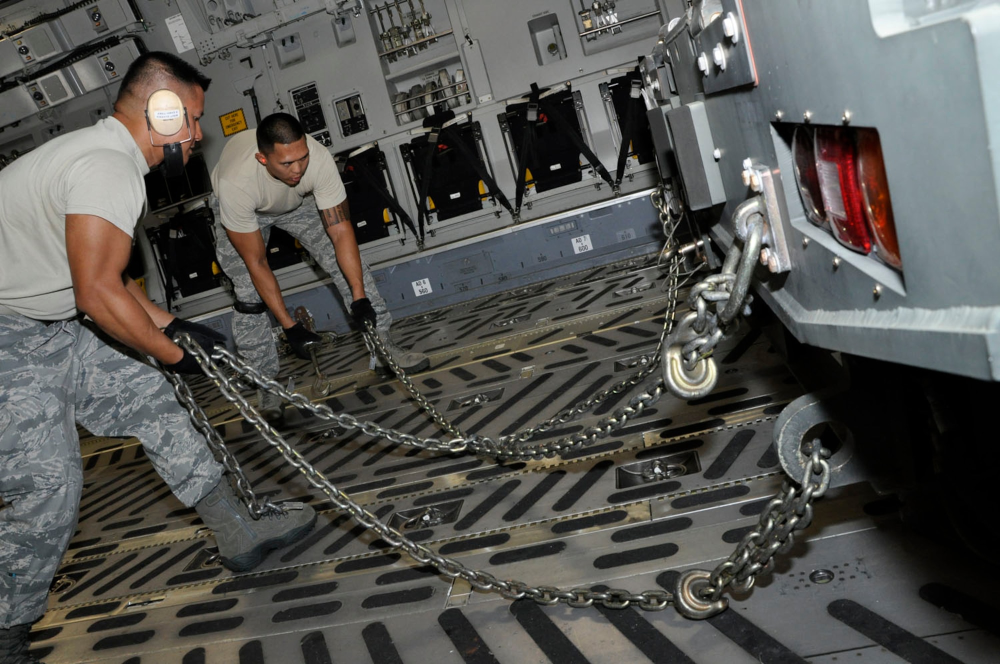 Master Sgt. Daniel Elvenia assists Staff Sgt. Ryan Kanagusuku tie down a cargo loader with chains Nov. 6. During the November drill weekend 48th Aerial Porters trained with Hawaii Air National Guardsmen to practice their ability to load and unload a C-17 Globemaster III. (U.S. Air Force photo/Master Sgt. Daniel Nathaniel)