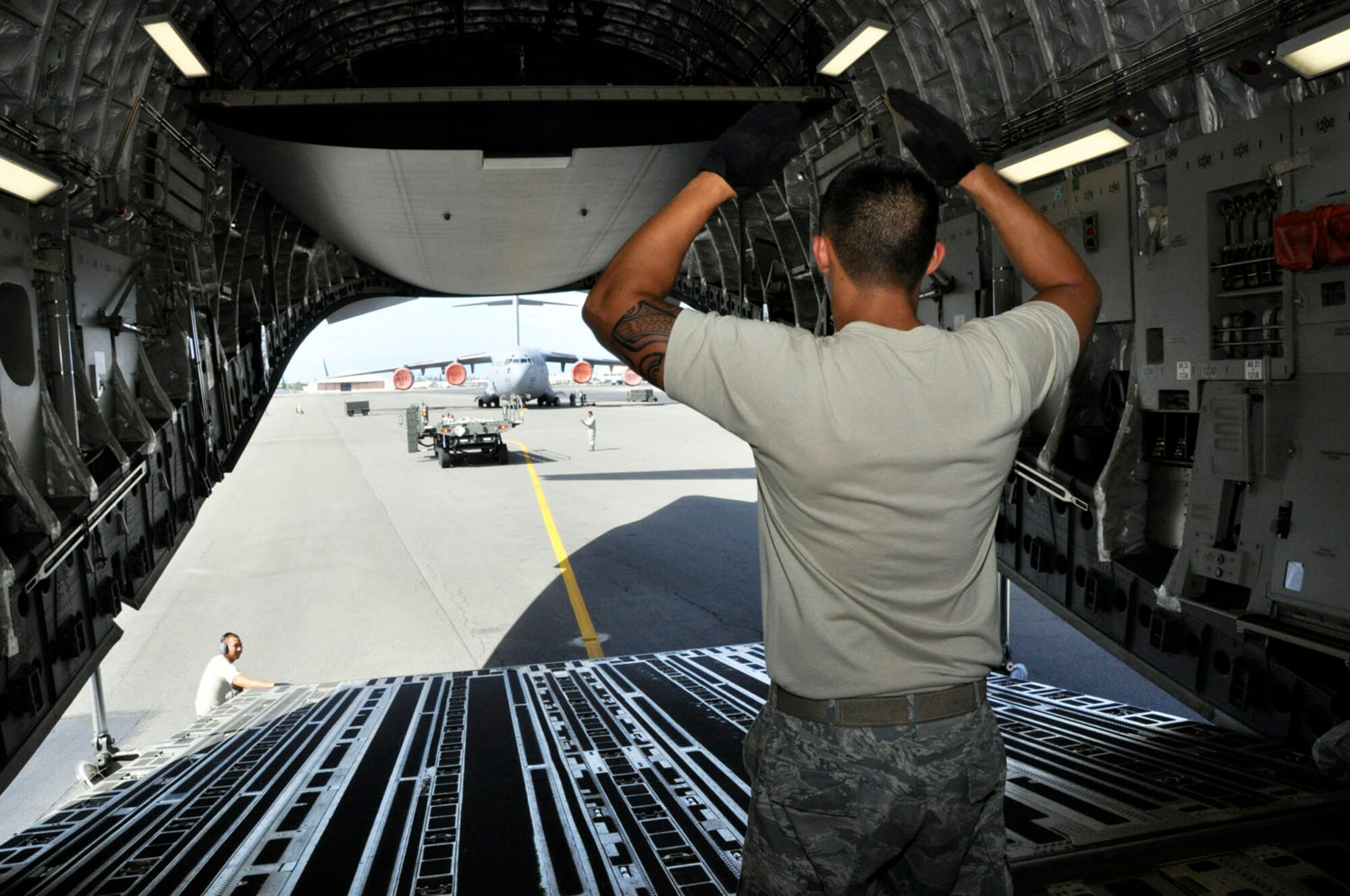 JOINT BASE PEARL HARBOR-HICKAM, Hawaii -- Staff Sgt. Dennis Dedicatoria, 48th Aerial Port Squadron, marshalls a cargo loader on the Hickam flightline Nov. 6. During the November drill weekend 48th Aerial Porters trained with Hawaii Air National Guardsmen to practice their ability to load and unload a C-17 Globemaster III. (U.S. Air Force photo/Master Sgt. Daniel Nathaniel)