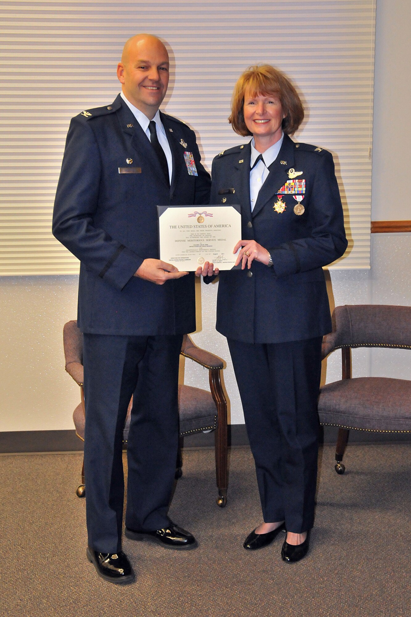 Col. Steven Vautrain, 439th Airlift Wing commander, presents Col. Lisa Tank, former 446th AW vice commander, with the Defense Meritorius Service Medal during her retirement ceremony held in the 446th Operations Group auditorium here Nov. 6.  Vautrain also presented her with the Legion of Merit Medal before the retirement orders were published.  Tank has served in various roles with the 446th AW since joining the Air Force Reserve in 1994.  (U.S. Air Force photo/Tech. Sgt. Tanya King)