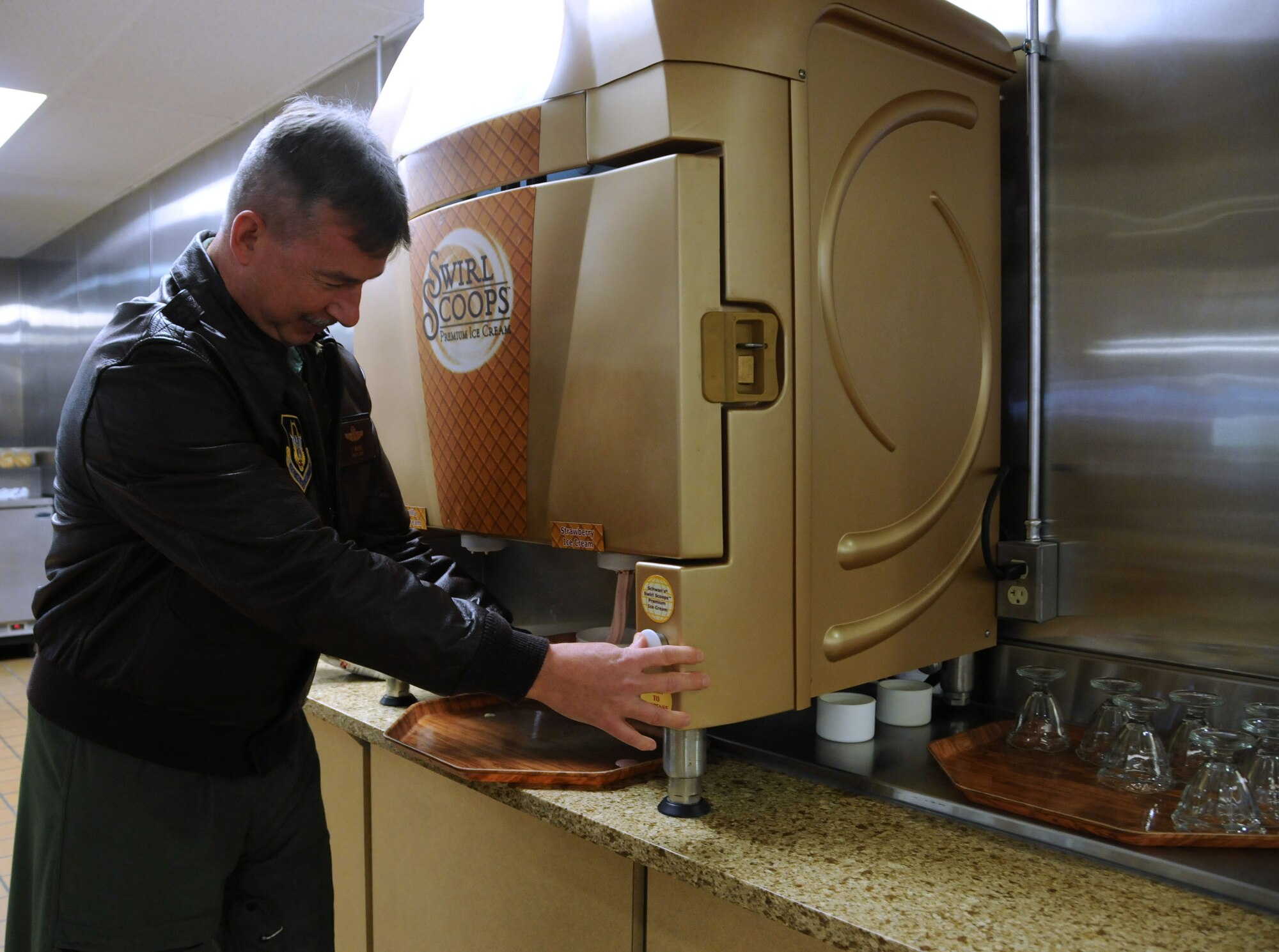 Senior Master Sgt. Dennis Moore, 709th Airlift Squadron C-5 B/M Instructor Loadmaster Flight chief, tries out the new soft-serve ice cream machine Nov. 5, 2011, inside the Patterson Dining Facility, Dover Air Force Base, Del. The ice-cream machine is one of several added features in the DFAC following a 19-day renovation. (U.S. Air Force photo/Senior Airman Tanisha Brown)