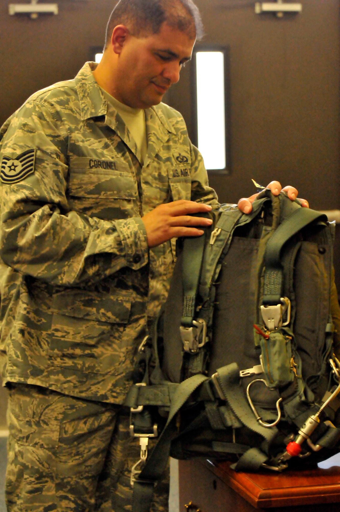 PATRICK AIR FORCE BASE, Fla. - Tech. Sgt. Xavier Coronel, aircrew flight equipment specialist, 920th Operations Support Squadron, inspects a parachute pack prior to placing it in the HC-130 King aircraft for use by the pararescuemen for the Cocoa Beach Air Show demonstration Nov. 4-5. AFE specialists typically take about 30 minutes to prepare the aircraft for the next day following a flight. (U.S. Air Force Photo/Capt. Ryan Liss)