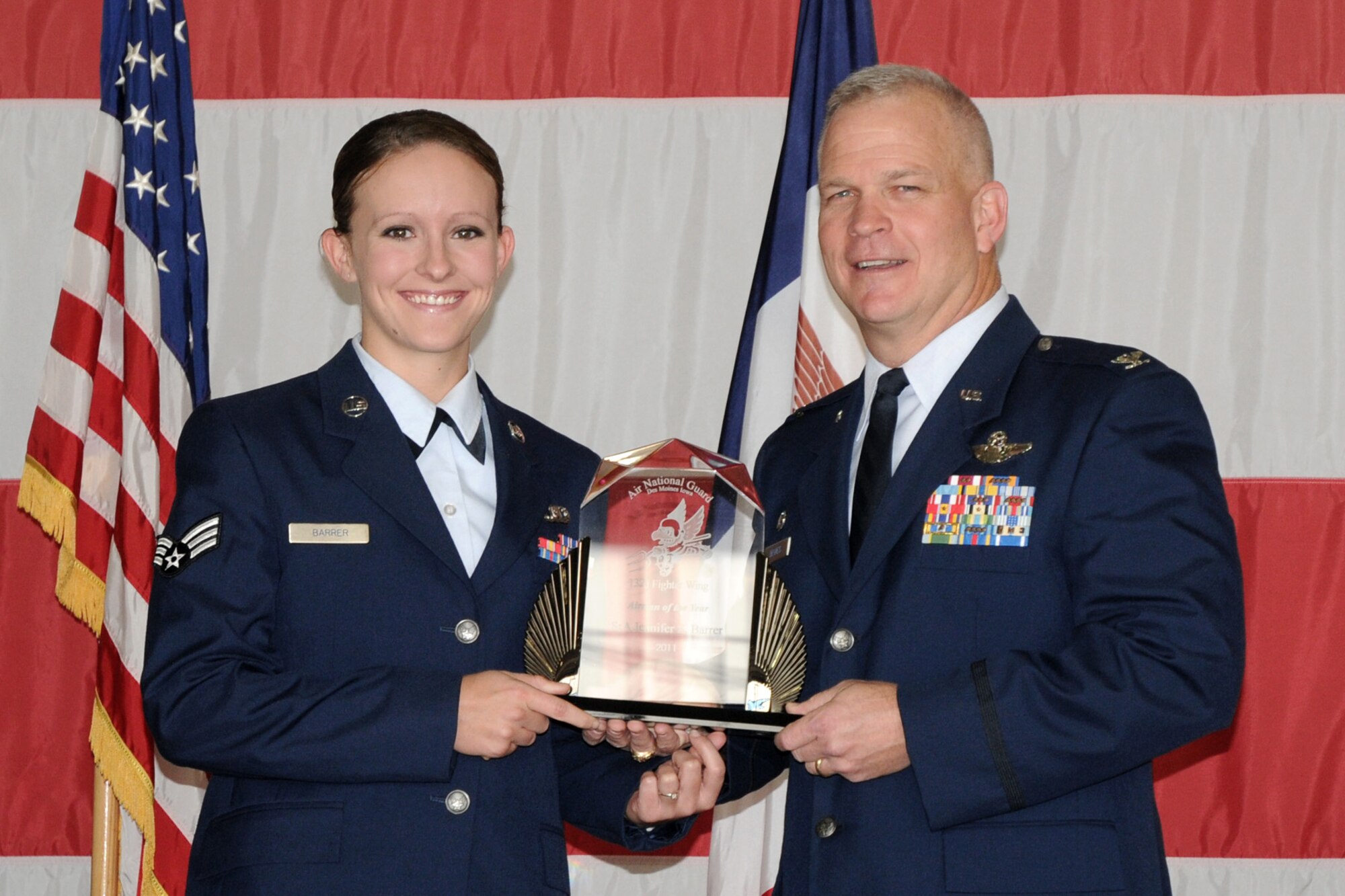 Col. Drew DeHaes (right) presents Senior Airman Jennifer Barrer (left) with the 2011 Airman of the Year award during the Awards Ceremony held in the hangar of the 132nd Fighter Wing, Des Moines, Iowa on November 6, 2011.  (US Air Force photo/Staff Sgt. Linda E. Kephart)(Released)