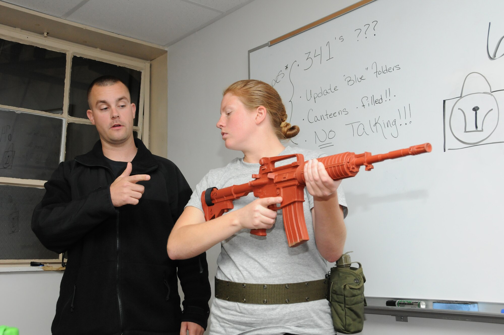 Senior Airman Sean Welch (left) instructs Airman Basic Adrienne Taylor on a mock M-4 rifle during defensive fighting position drills, Pease Air National Guard Base, New Hampshire, October 23, 2011.  Airman Welch and Airman Taylor are assigned to the 157th Air Refueling Wing Student Flight here at Pease.  (U.S. Air Force photo/Staff Sgt. Curtis J. Lenz) 