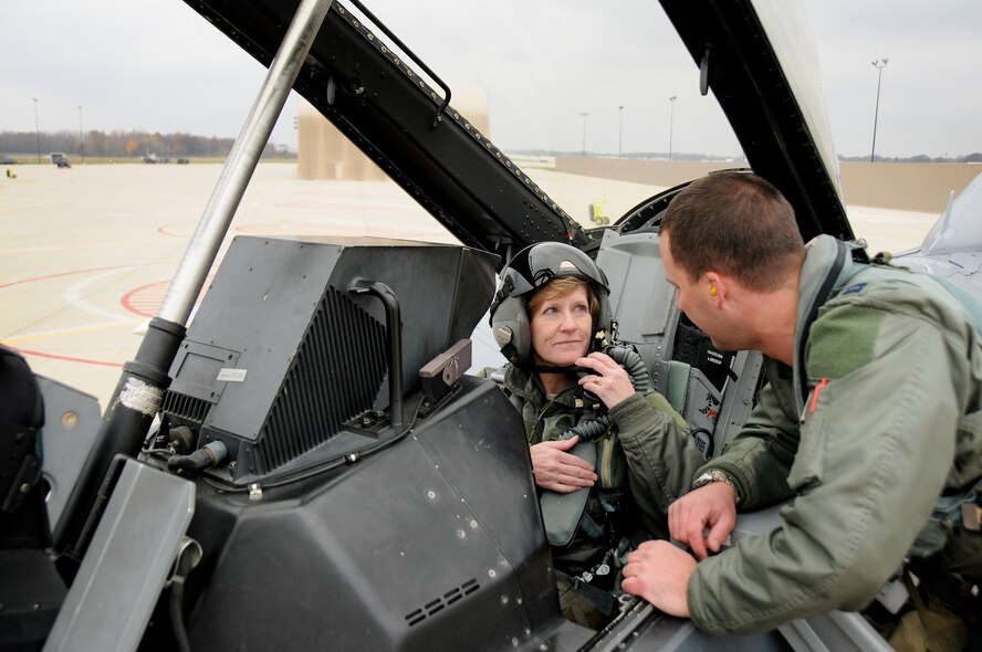 Capt. Brian Cherolis, F-16 pilot with the 180th Fighter Wing, explains key components of the F-16 to Maj. Gen. Deborah Ashenhurst, Ohio National Guard Adjutant General, to the hanging harness parachute simulator prior to a familiarization flight. The 180th Fighter Wing hosted Maj. Gen. Ashenhurst for an F-16 familiarization flight over the Grayling Range in Northern Michigan Nov., 3.  Ashenhurst completed aircrew flight equipment and life support training and took to the skies for an up-close look at how the 180th FW supports joint combat operations to protect and support ground forces.  Maj. Gen. Ashenhurst is responsible for the military preparedness of the Ohio Organized Militia, which includes the Ohio Army and Air National Guard.