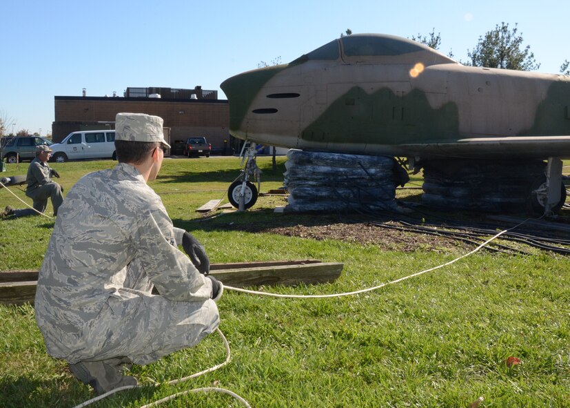 Members of the 135th and 175th Maintenance Squadron’s crash recovery teams, Maryland Air National Guard, prepare to remove the supports of the F-86 static display once the lifting bags raise the aircraft high enough on November 5, 2011 at Warfield Air National Guard Base, Baltimore, MD. The team of over 50 worked to move the Korean War aircraft to make room for the new 135th operations building.  (National Guard Photo By Staff Sgt. Benjamin Hughes/RELEASED)