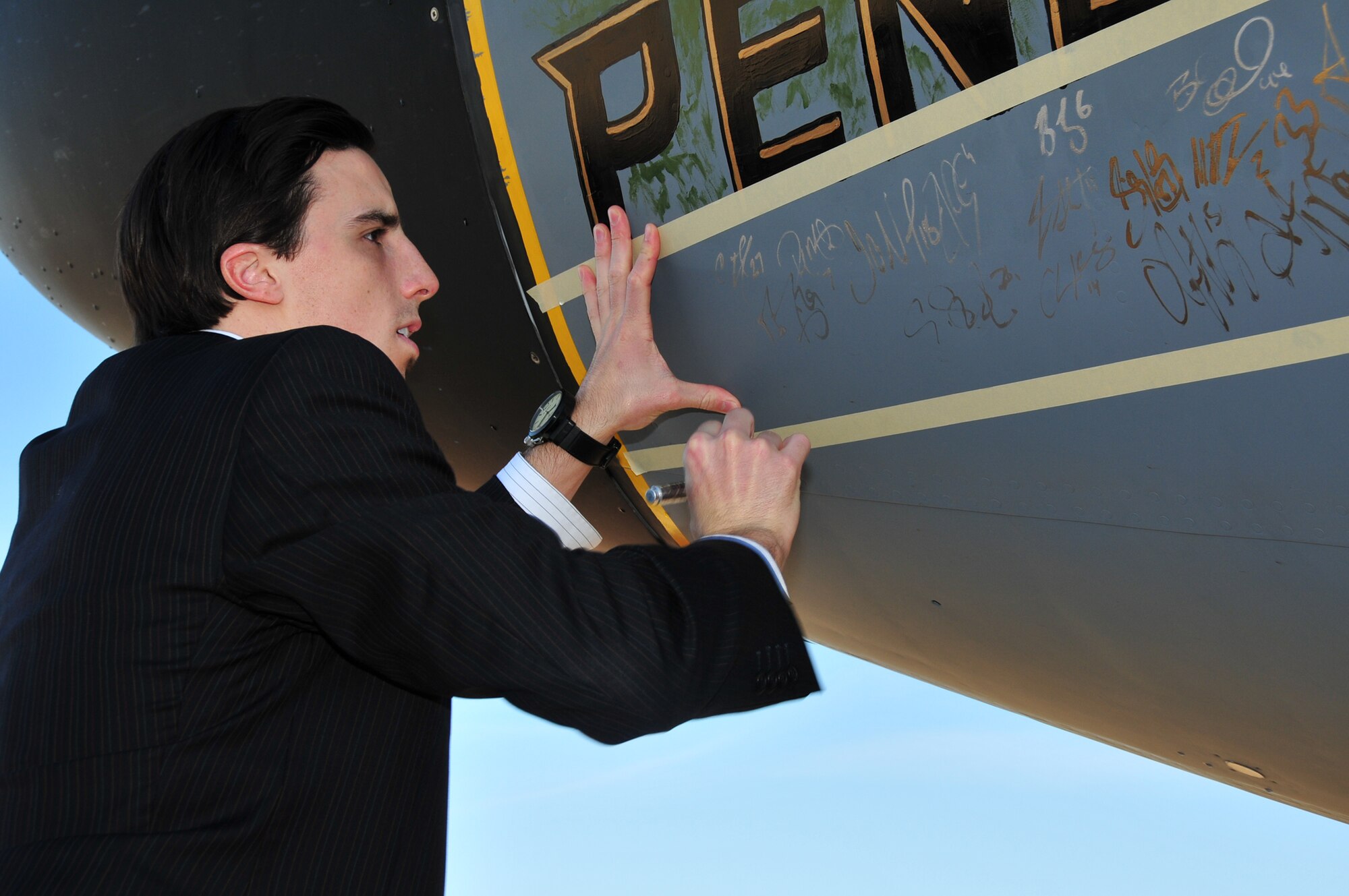 Members of the Pittsburgh Penguins hockey team autograph one of the 171st Air Refueling Wing's KC135 stratotankers which displays nose art honoring the team November 2. (National Guard photo by Master Sgt. Ann Young/Released)