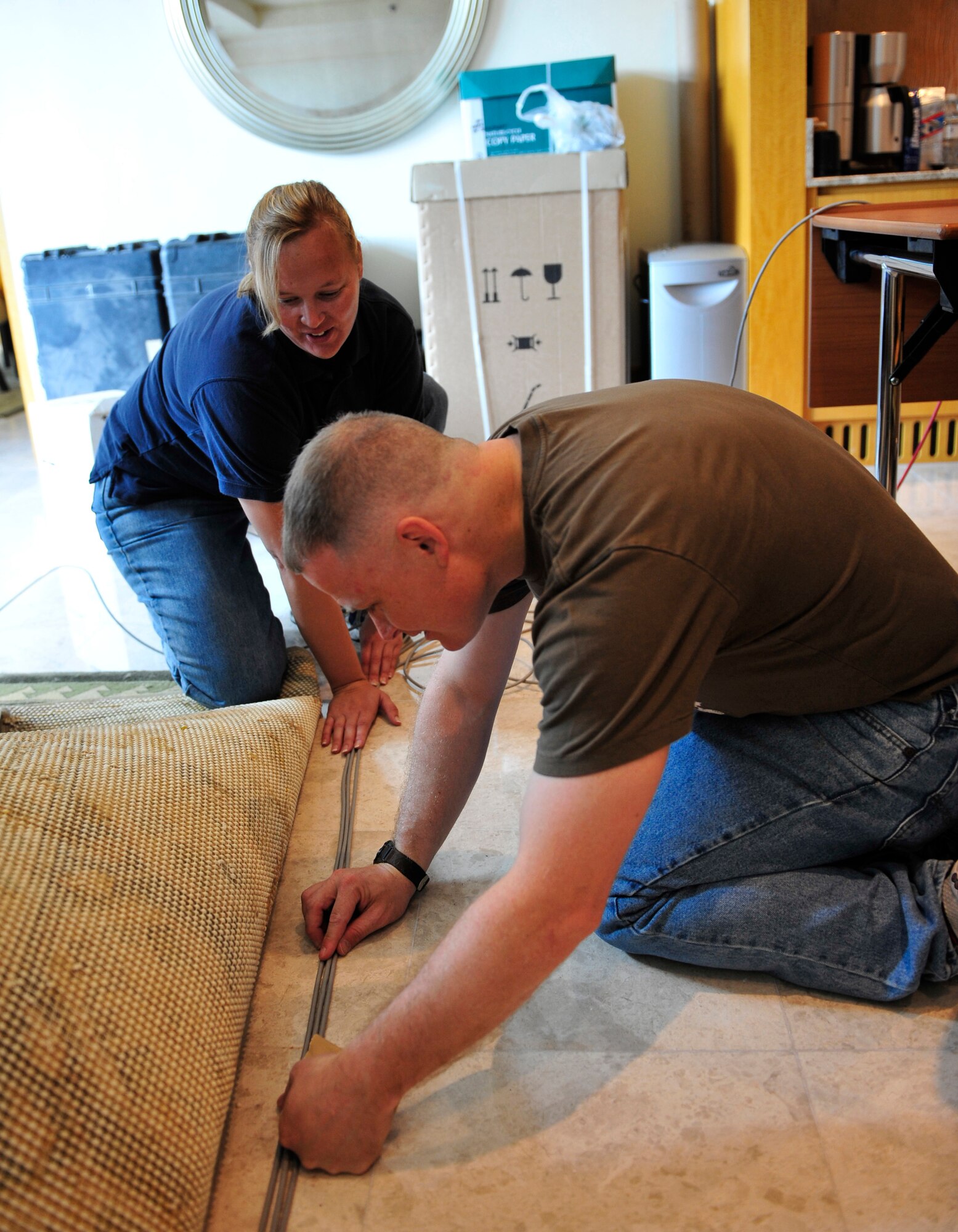 Senior Master Sgt. Troy Baird, from the 380th Expeditionary Communications Squadron, and Amanda Campbell, a contractor with the 380th ECS, install Internet cables in the main operations center for the 2011 Dubai Airshow.  Baird and Campbell are part of a communications team from U.S. Air Forces Central Command that was sent to Dubai to set up three operations centers for the bi-annual event. The Airshow will highlight a variety of U.S. Air Force, Navy and Army aircraft showcasing the range of U.S. military airpower capabilities. Aircrew and support personnel from bases in the gulf region, Europe and the U.S. are participating in the event, which is expected to draw more than 55,000 visitors.  (U.S. Air Force Photo/Tech. Sgt. Patrick Mitchell)
