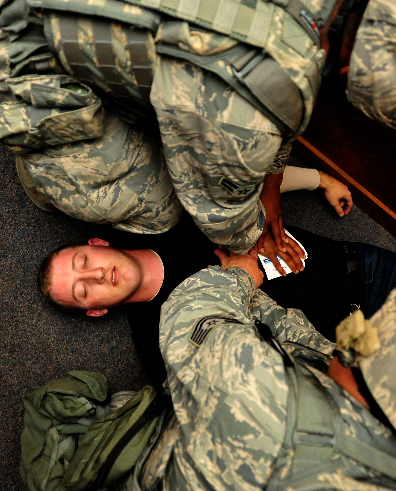 MISAWA AIR BASE, Japan – U.S. Air Force Airman 1st Class Diandre Zachary, top, and Tech. Sgt. Hiram Bundy, bottom, both 35th Security Forces Squadron perform self aid buddy care on role player Staff Sgt. Matthew Cella during an operational readiness exercise here Nov. 6. The 35th Fighter Wing is currently going through an ORE in preparation for an operational readiness inspection in December. (U.S. Air Force photo/Staff Sgt. Nathan Lipscomb)