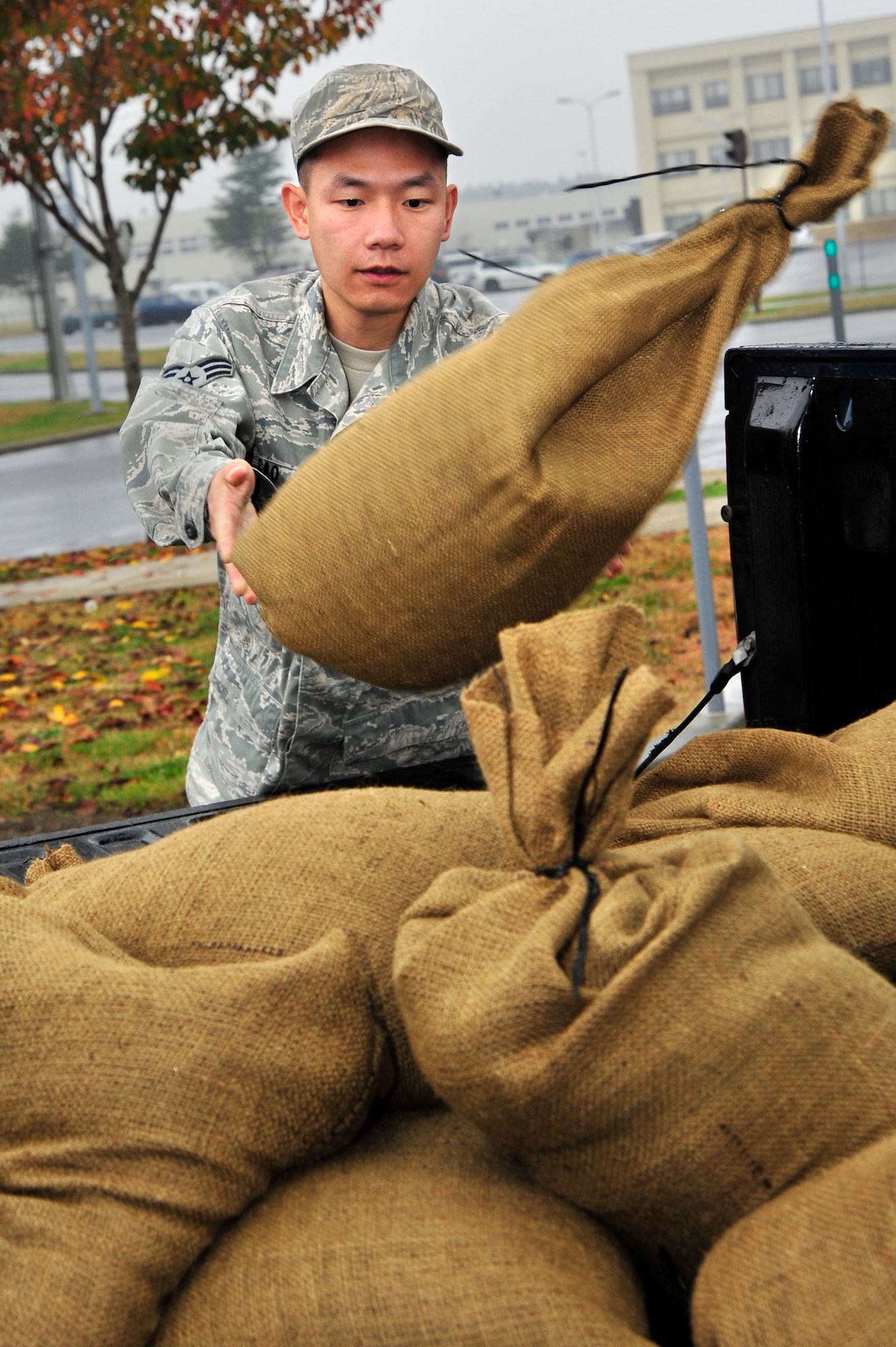 MISAWA AIR BASE, Japan – U.S. Air Force Senior Airman Zhile Cao, 35th Communications Squadron tosses sand bags into the back of a pickup truck. The sand bags will be used to protect building in case of a simulated attack during an operational readiness exercise here Nov. 6. The 35th Fighter Wing is currently going through an ORE in preparation for an operational readiness inspection in December. (U.S. Air Force photo/Staff Sgt. Nathan Lipscomb)