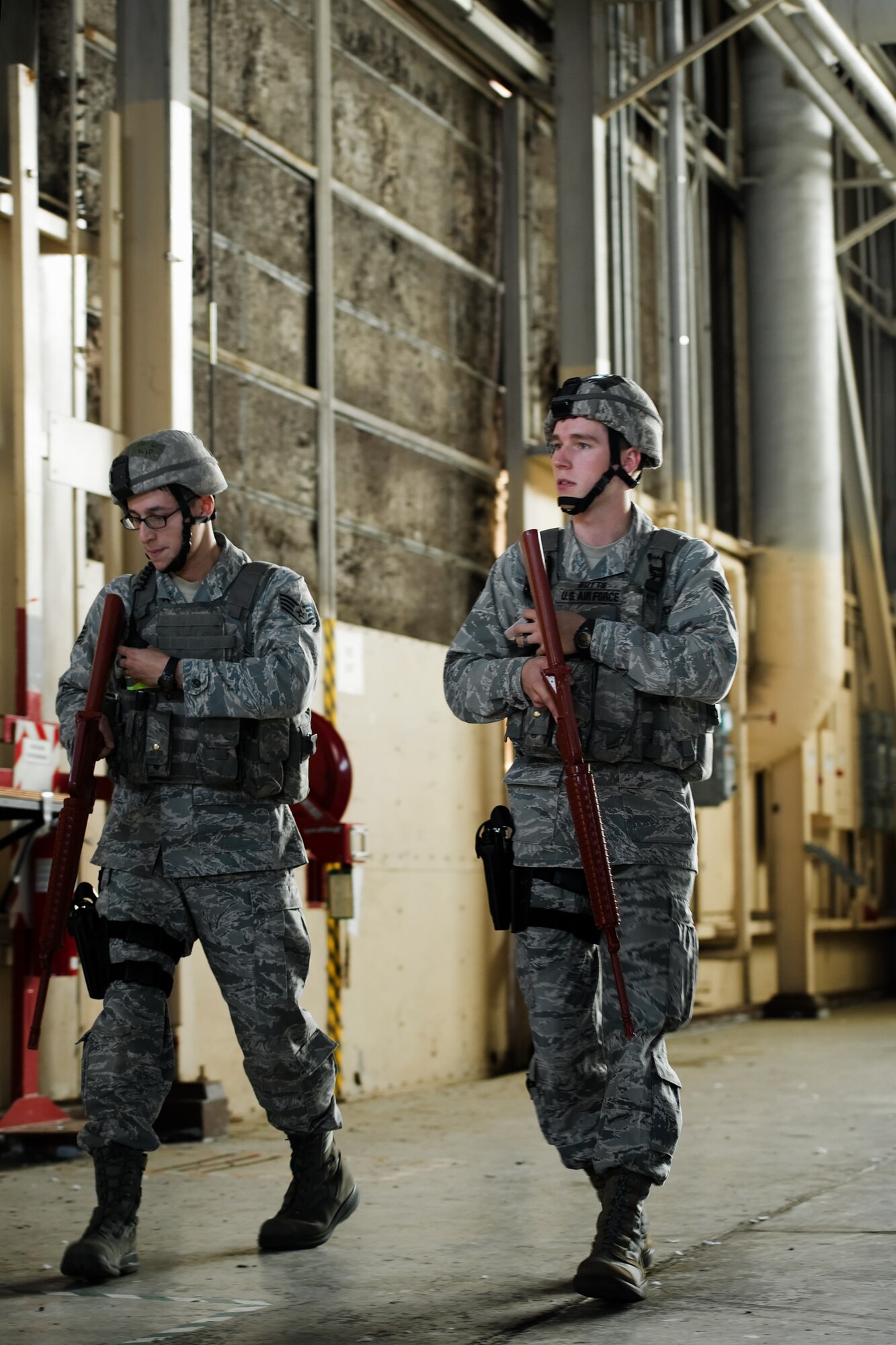 YOKOTA AIR BASE, Japan -- (Left to right) Staff Sgt. Rafael Quiroz and Senior Airman James Butts, patrolmen from the 374th Security Forces Squadron, patrol a hangar during an active shooter scenario at Yokota Air Base, Japan, Nov. 7, 2011. Yokota is participating in a week-long exercise to maintain operational readiness capabilities. (U.S. Air Force photo/Osakabe Yasuo)