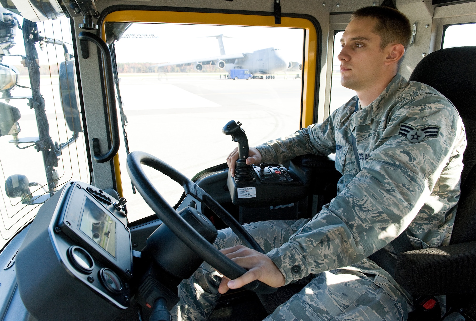 Senior Airman Daniel Thomas, a pavement and construction technician with the 436th Civil Engineer Squadron, drives a heavy vehicle, designed to sweep up snow and other debris Nov. 2, 2011, at Dover Air Force Base, Del., as part of the annual Snow Parade. The 436th CES hosted this annual event, allowing commanders the opportunity to ride or drive down the flightline.  (U.S. Air Force photo by Roland Balik)