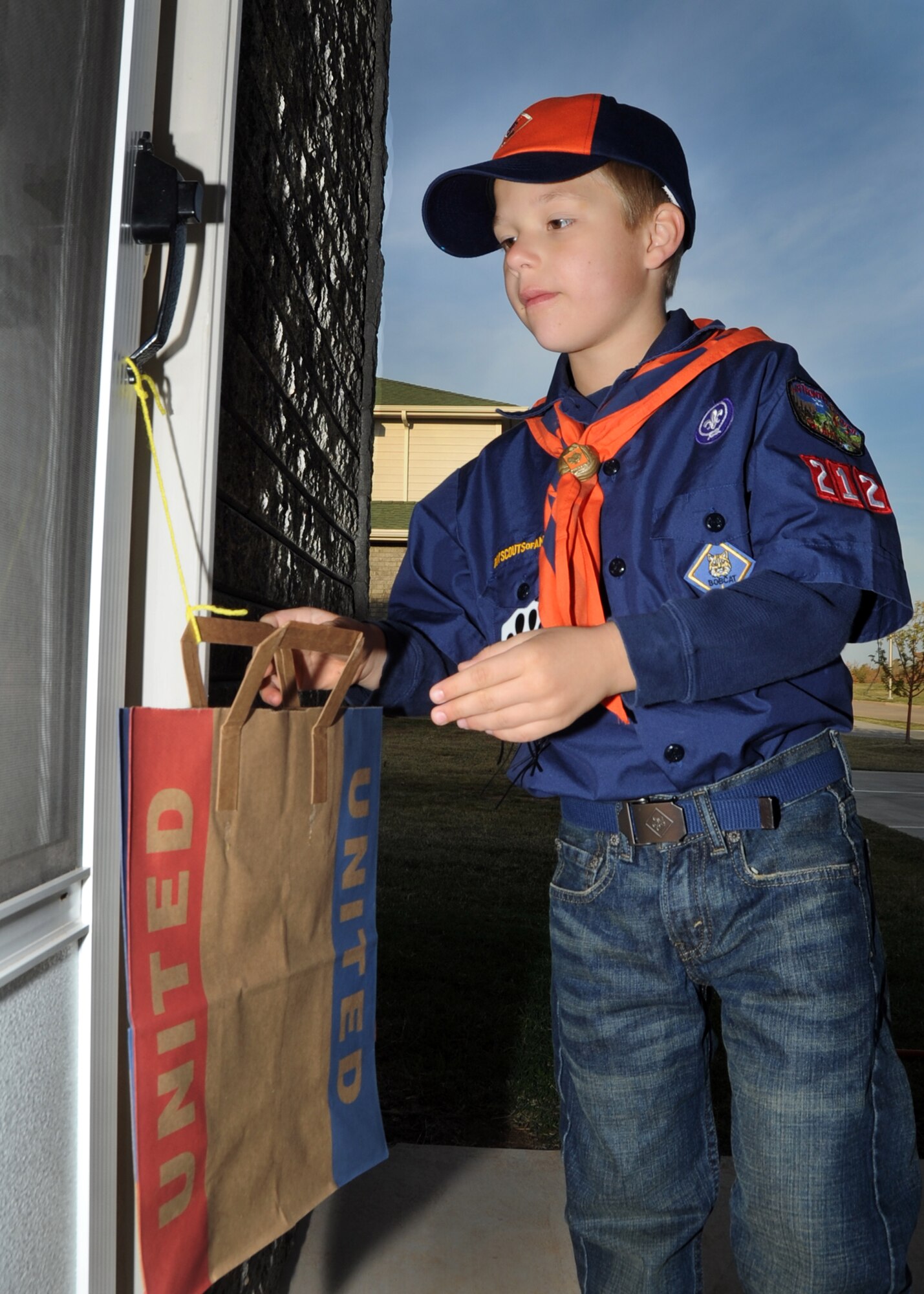 ALTUS AIR FORCE BASE, Okla. – Ethen Edwards, Tiger Scouts pack 212, places bags for Harvest for the Hungry on base housing porches to collect Items for the Community Cupboard Nov. 05, 2011. Harvest for the Hungry restocks the Community Cupboard with food and household items that less fortunate families cannot always afford.  (U.S. Air Force photo by Airman 1st  Class Levin Boland / 97th Air Mobility Wing Public Affairs / Released)
