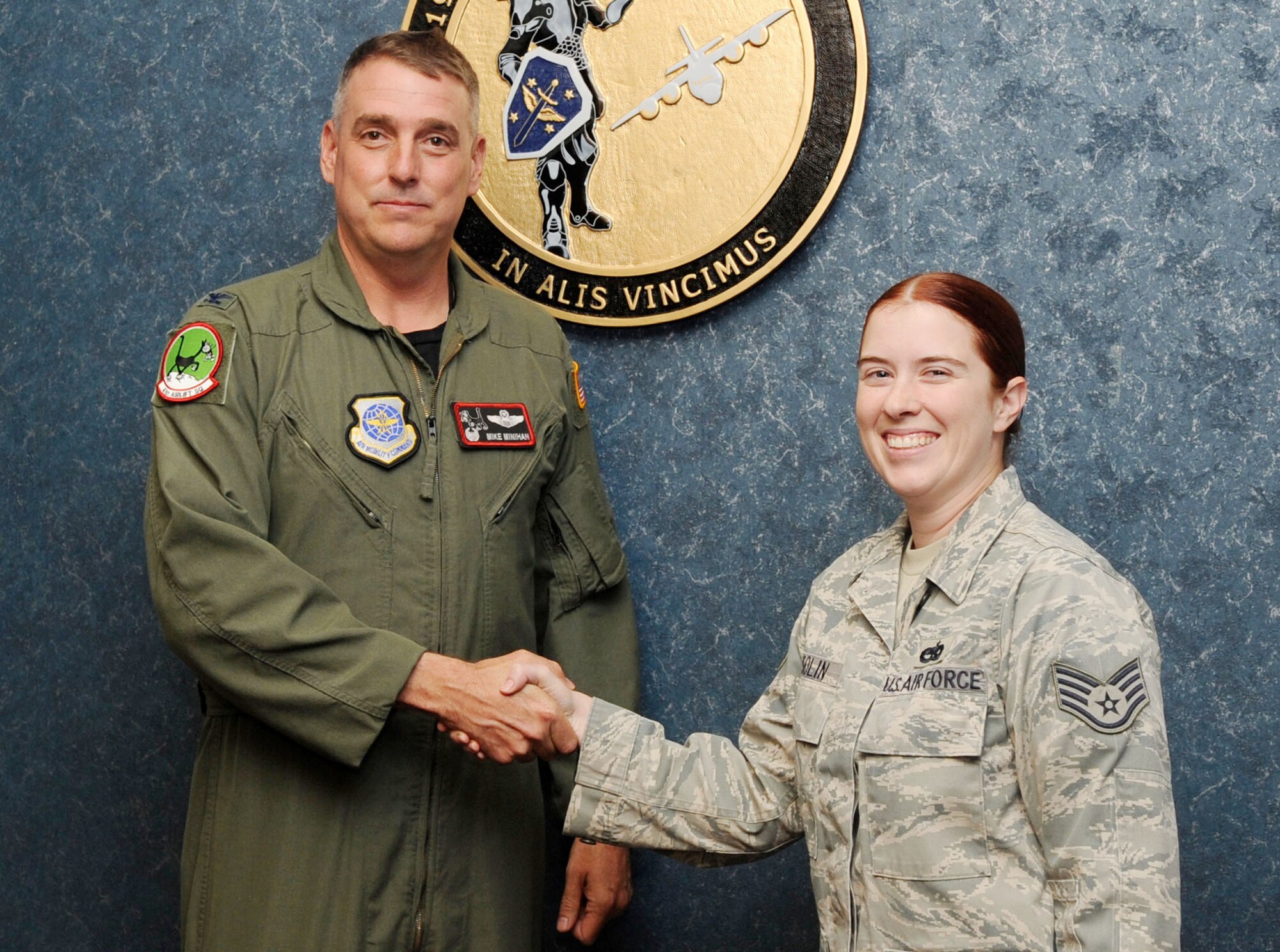 Col. Mike Minihan, 19th Airlift Wing commander, presents a commander’s coin Oct. 31, 2011, to Staff Sgt. Tami Osolin, 19th Maintenance Group facility manager, at Little Rock Air Force Base, Ark. Osolin oversees 70 aircraft maintenance facilities and has refurbished the periodic investigation program by correcting 43 errors. (U.S. Air Force Photo by Staff Sgt. Jim Araos)