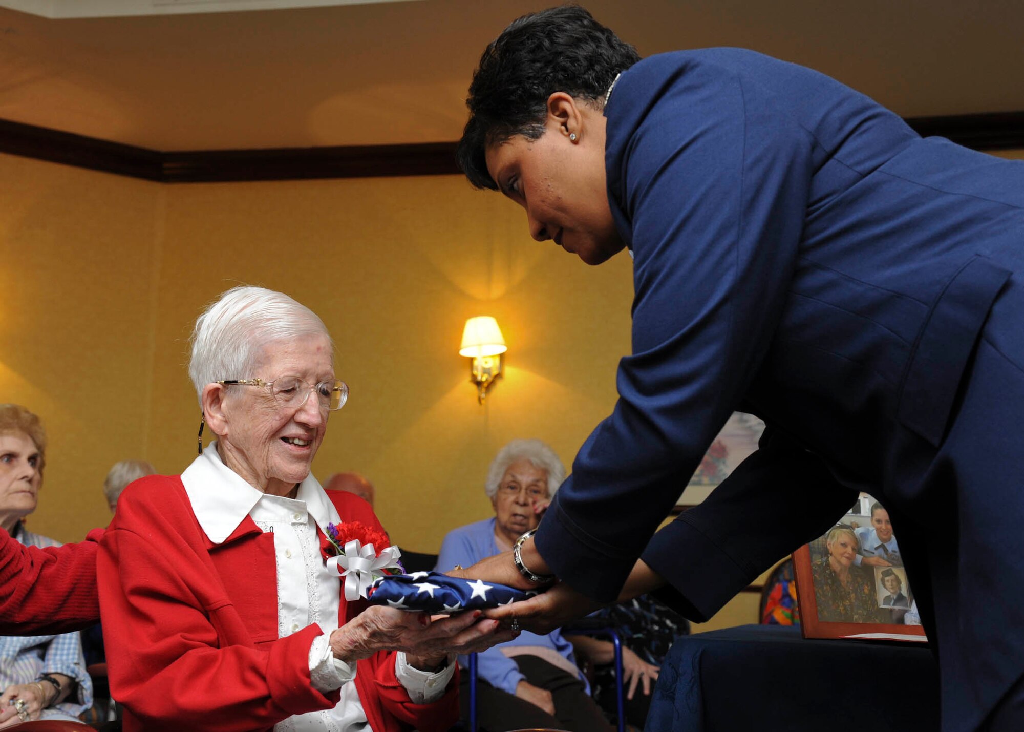Col. Yolanda Bledsoe, 56th Medical Group commander, presents 98-year-old retired Maj. Anna “Det” Dorsey a flag during a ceremony Oct. 27 at Freedom Inn in Sun City West. The flag was flown over the USS Arizona Memorial in Pearl Harbor in her honor. When the United States entered World War II, Dorsey was one of the fewer than 1,000 nurses in the U.S. Army.   (U.S. Air Force photoy by Senior Airman Darlene Seltmann)