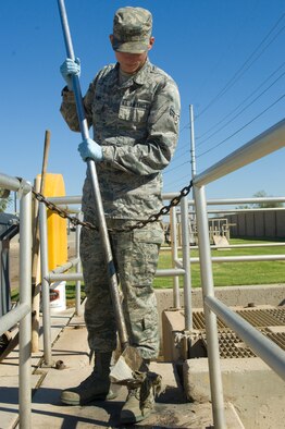 Airman 1st Class Cody Shows, 56th CES water and fuels maintenance technician, skims bits of rubbish from the water before it continues through the treatment process at the waste water treatment plant at Luke Air Force Base.  (U.S. Air Force photoy by Staff Sgt. Jason Colbert)