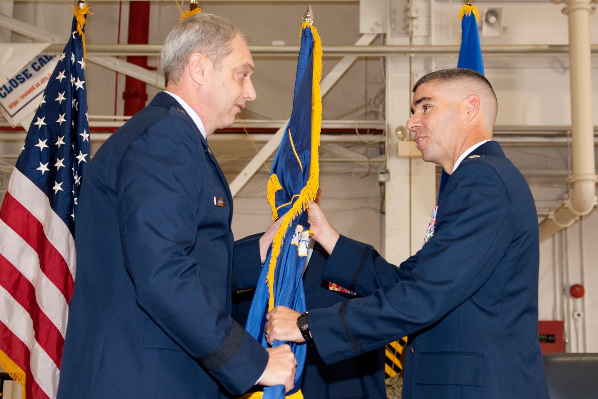 U.S. Air Force Brig. Gen. John Mooney III, 307th Bomb Wing commander, presents the 307th Maintenance Group (MXG) flag to U.S. Air Force Lt. Col. Kenneth Rose during an Assumption of Command ceremony at Barksdale Air Force Base, La., Nov. 6, 2011. Rose, former director of the COMBAT SHIELD Electronic Warfare Assessment Program at Eglin Air Force Base, Fla., assumed command of the 307th MXG, which maintains the B-52H Stratofortress. (U.S. Air Force photo by Master Sgt. Greg Steele/Released)
