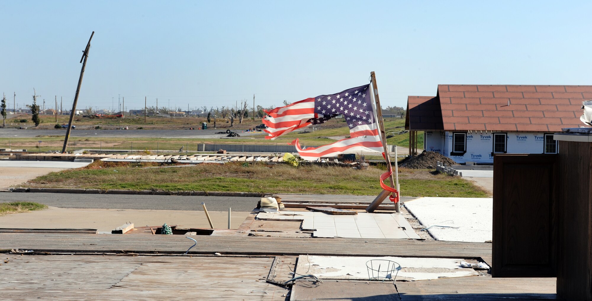 JOPLIN, Mo. -- A battered flag still flies at the site of one of the hardest hit areas by a tornado in Joplin that left several people homeless May 22. Airmen assigned to the 509th Civil Engineer Squadron at Whiteman Air Force Base volunteered with Habitat for Humanity Nov 1 to build 10 homes in 10 days for the residents that lost their homes. (U.S. Air Force photo/Senior Airman Laura Goodgame)