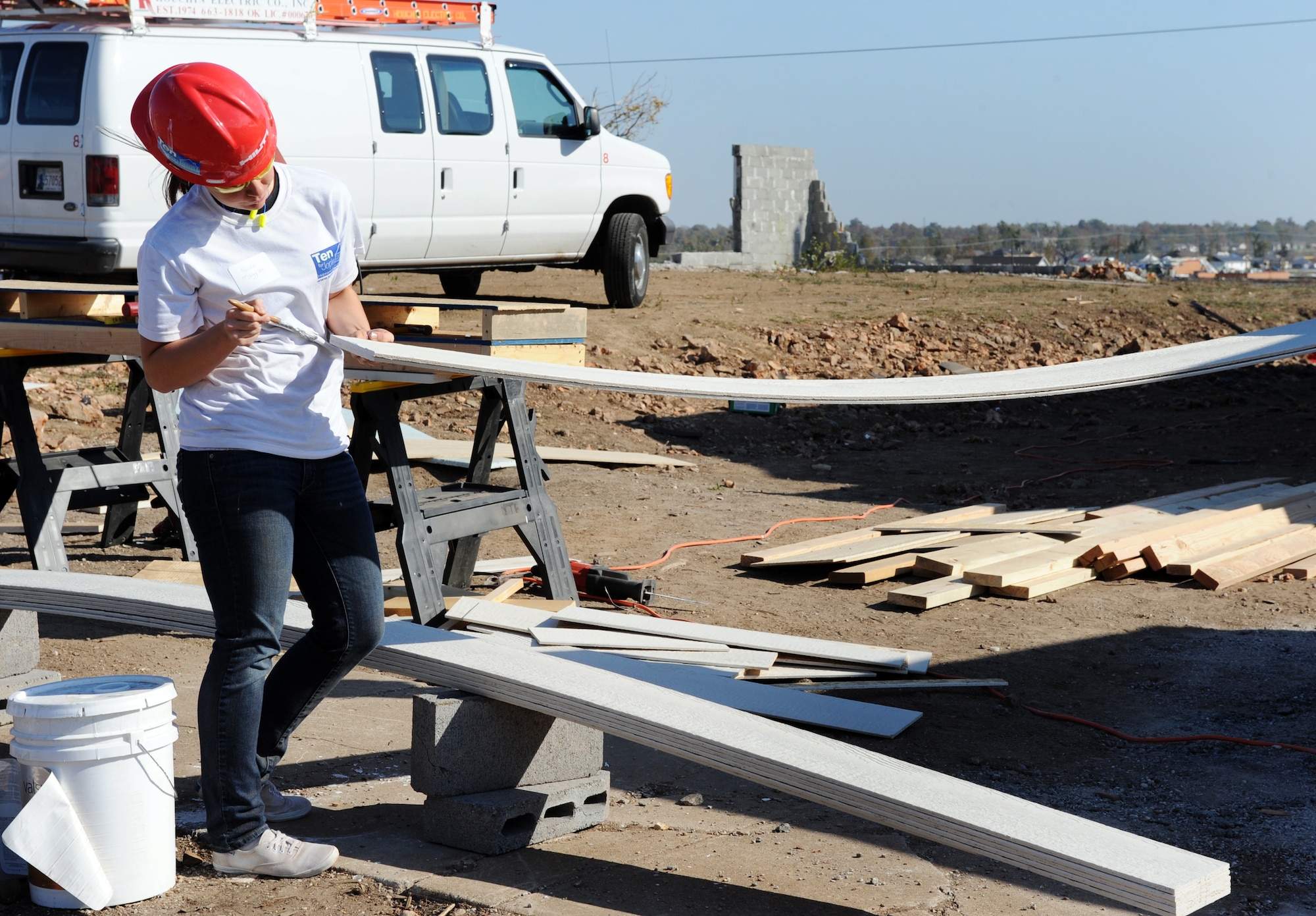 JOPLIN, Mo. -- Airman 1st Class Nicole Magyari paints the end of a piece of siding during the 10 homes in 10 days project Nov. 1, 2011. The project was sponsored by Habitat for Humanity, a non-profit organization devoted to building simple, decent, and affordable housing for people who are without homes. Many Joplin residents lost their home in the May 22 Joplin tornado. Magyari is assigned to the 509th Civil Engineer Squadron. (U.S. Air Force photo/Senior Airman Laura Goodgame) 