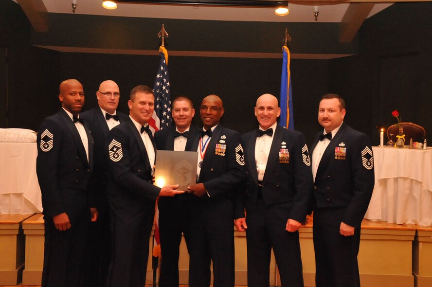 Current and past chief master sergeants from the 916th Air Refueling Wing present their newest chief, Chief Terry McCabe, his plaque at the 916th ARW Dining Out and NCO Induction Ceremony on Nov. 5, 2011. (USAF photo by SrA Meredith A.H. Thomas, 916ARW/PA)