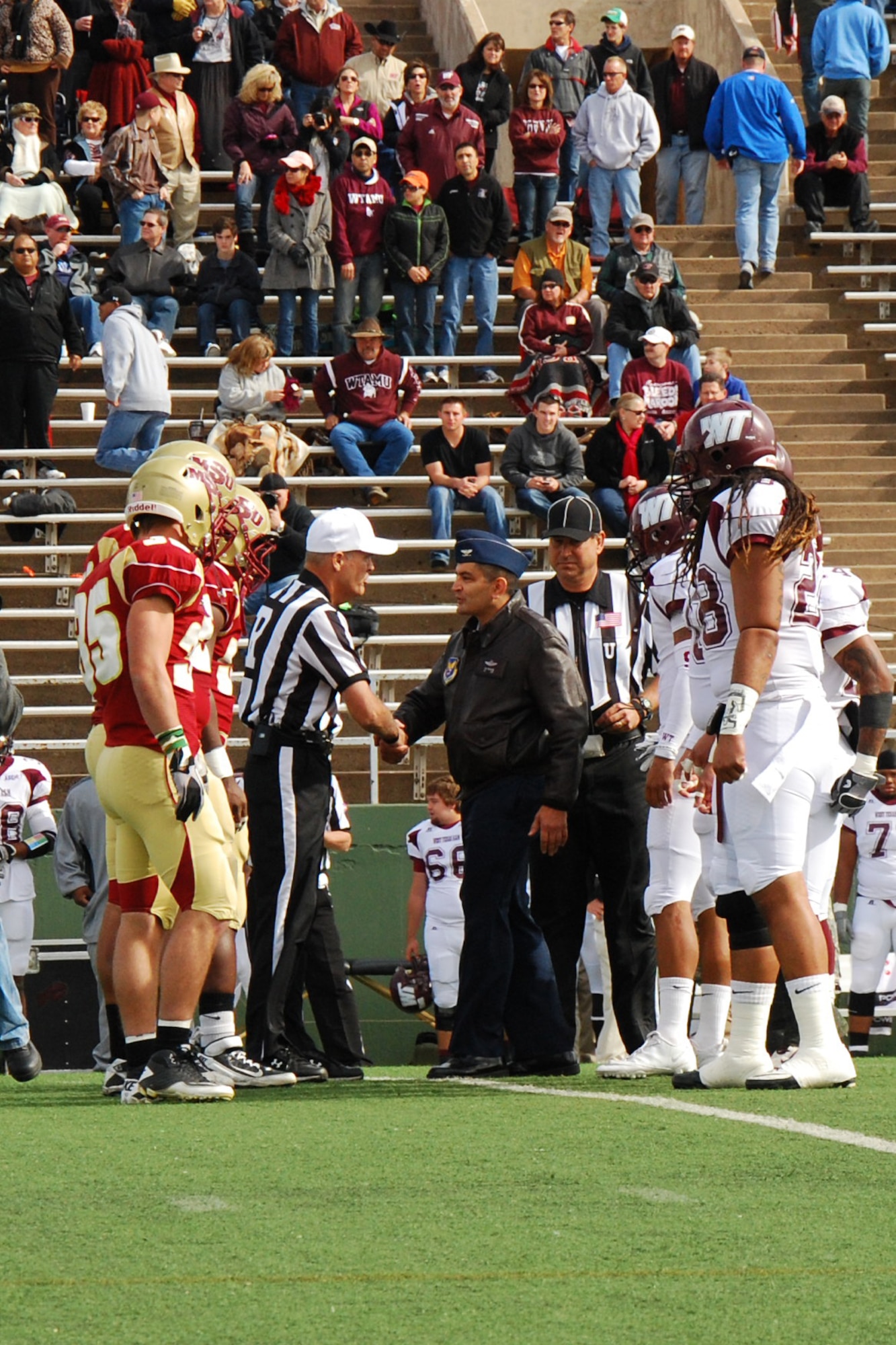 Col. Om Prakash, 82nd Training Wing vice commander, and Col. Dieter Bareihs, 80th Flying Training Wing commander, participate in the coin toss for the Midwestern State University military appreciation game against West Texas A&M University at Memorial Stadium, Wichita Falls, Texas, Nov. 5, 2011. Saturday’s game included a T-6 Texan II flyover by the 80th Flying Training Wing, a presentation to Sheppard and Fort Sill commanders, and the inclusion of a formation of Airmen and Soldiers in the half time show. (U.S. Air Force photo/Capt. Brittany Martin)