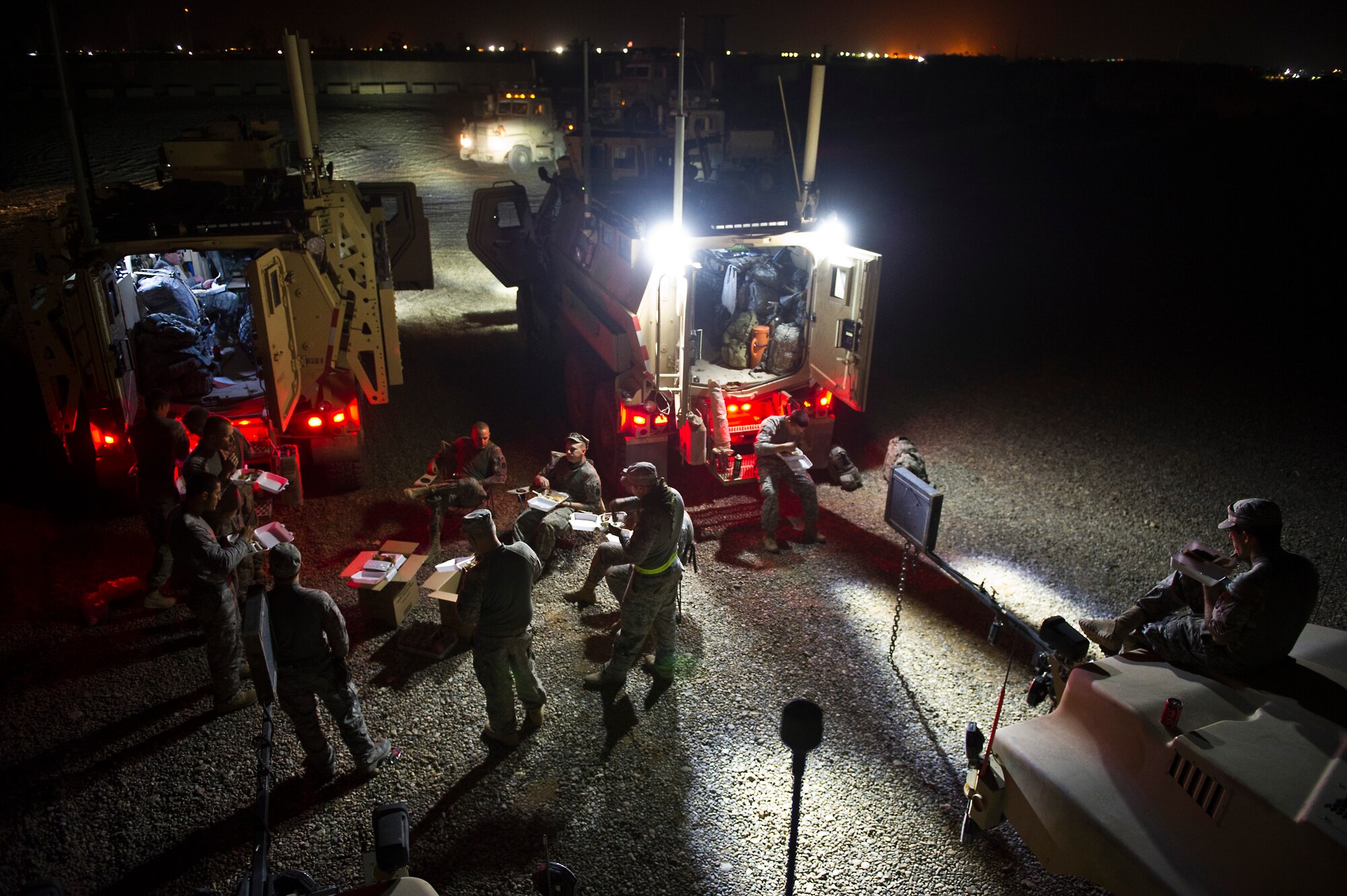 U.S. Air Force members assigned to the 70th medium truck detachment and U.S. Army Minnesota National Guard members assigned to B-Troop, 1-94 Cavalry, Pine City MN., eat dinner before leaving Forward Operating Base Warrior, Iraq on Oct. 28, 2011. The joint team drove more than 1,100 miles and hauled 43 truckloads of supplies and equipment out of Iraq. The 70th MTD runs the convoy operations while B-Troop provides security. (U.S. Air Force Photo/Master Sgt. Jeffrey Allen)