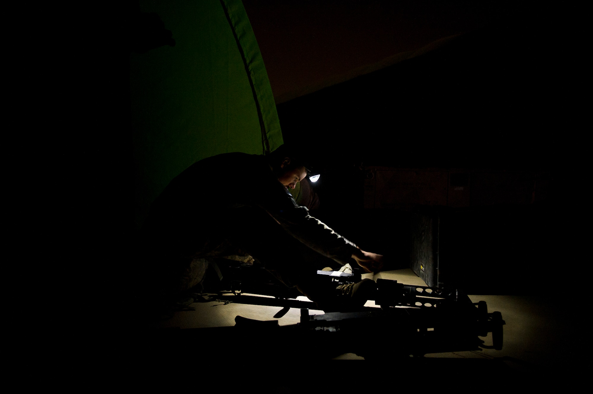 U.S. Army Specialist Nathan Hietala, gunner assigned to Minnesota Army National Guard's B-Troop, 1-94 Cavalry, Pine City MN., and Esko, MN., native cleans a .50 caliber machine gun outside of his tent after a mission at Joint Base Balad, Iraq on Oct. 26, 2011. B-Troop is providing security for a convoy of 43 vehicles tasked with hauling equipment and supplies out of Iraq. (U.S. Air Force Photo/Master Sgt. Jeffrey Allen)