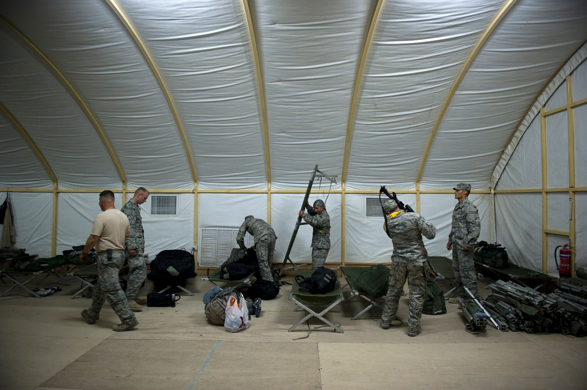 U.S. Air Force Airmen assigned to the 70th medium truck detachment set up cots in a tent after completing the first leg of a 7-day convoy on Oct. 23, 2011.  As bases begin to shrink and personnel support services shut down, the sleeping accommodations for trucker crews become more limted. The team is taking 43 vehicles and 60 passengers more than 1,100 miles through Iraq to transport equipment and supplies out of the country in order to meet the military transition deadline. (U.S. Air Force Photo/Master Sgt. Jeffrey Allen)