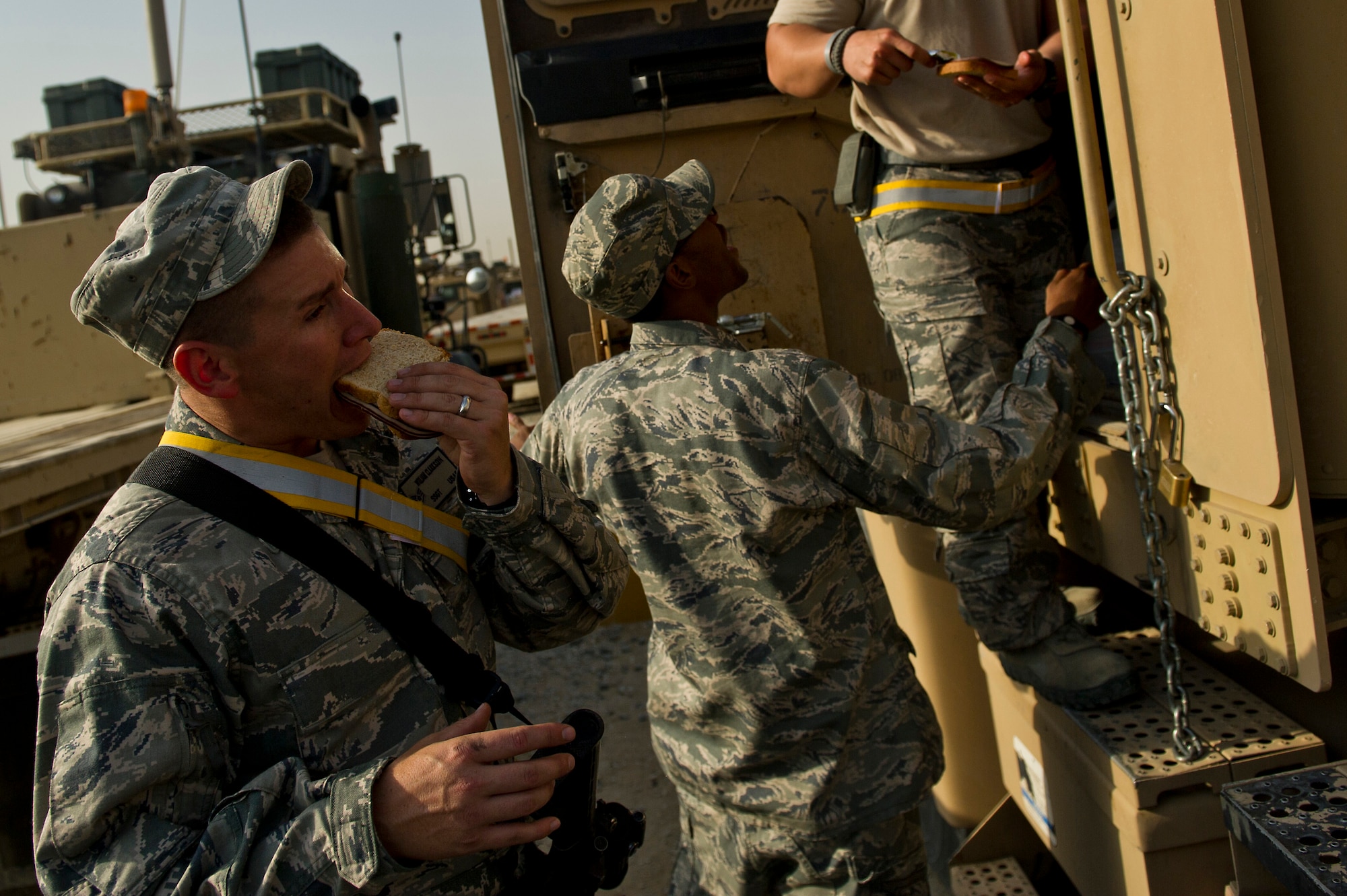 U.S. Air Force Staff Sgt. William Clarkson (right) an Auburn, Calif. native and vehicle operator assigned to the 70th medium truck detachment, eats a turkey sandwich before a mission on Oct. 23, 2011 at an undisclosed location in Southwest Asia. Clarkson and Olson drove all night in a convoy to get to Forward Operating Base Warrior before loading the trucks and are scheduled to depart later in the evening. The convoy of 43 vehicles and 60 passengers traveled more than 1,100 miles through Iraq. (U.S. Air Force Photo/Master Sgt. Jeffrey Allen)
