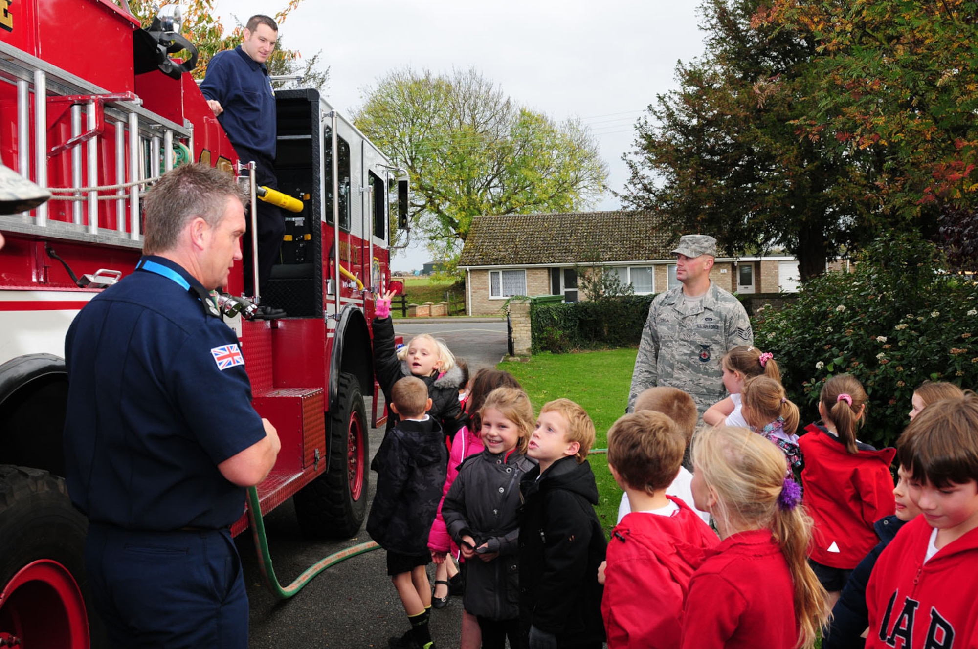 WEST ROW, England -- Watch Manager Ken Cross, left, 423rd Civil Engineer Squadron Fire Department, RAF Alconbury, explains equipment and fire procedures to children from West Row Primary School Nov. 3, 2011. Firefighter Daniel Manning, Staff Sgt. Kyle Dulin and Senior Airman Shayne Anglin (not pictured), all 100th Civil Engineer Squadron Fire Department, visited the local primary school to foster good community relations. (U.S. Air Force photo/Karen Abeyasekere)