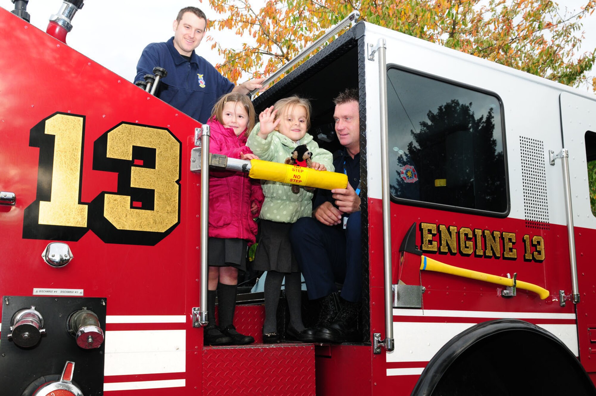 WEST ROW, England -- Firefighter Daniel Manning, left, 100th Civil Engineer Squadron Fire Department, and Watch Manager Ken Cross, 423rd Civil Engineer Squadron Fire Department, RAF Alconbury, give children a tour of their fire engine Nov. 3, 2011. The RAF Mildenhall Fire Department visited West Row Primary School and gave children a demonstration of fire equipment. Cross organized the event to foster good relations within the community. (U.S. Air Force photo/Karen Abeyasekere)