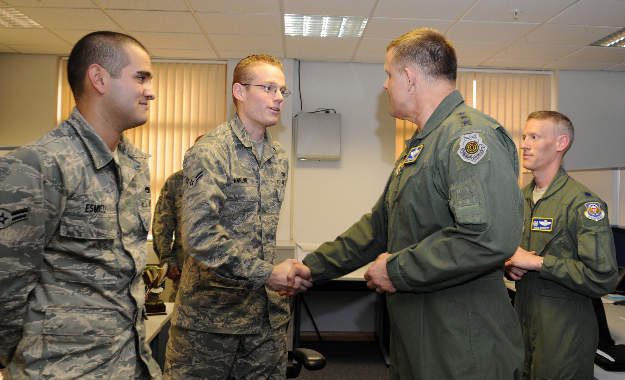 RAF MILDENHALL, England – Lt. Gen. Frank Gorenc, 3rd Air Force commander, presents his coin to Airman 1st Class Richard Harline, 100th Aircraft Maintenance Squadron, during a base visit here Nov. 4, 2011. Harline was recognized for his work that contributed to the base involvement in Operation Unified Protector. (U.S. Air Force photo/ Senior Airman Rachel Waller)