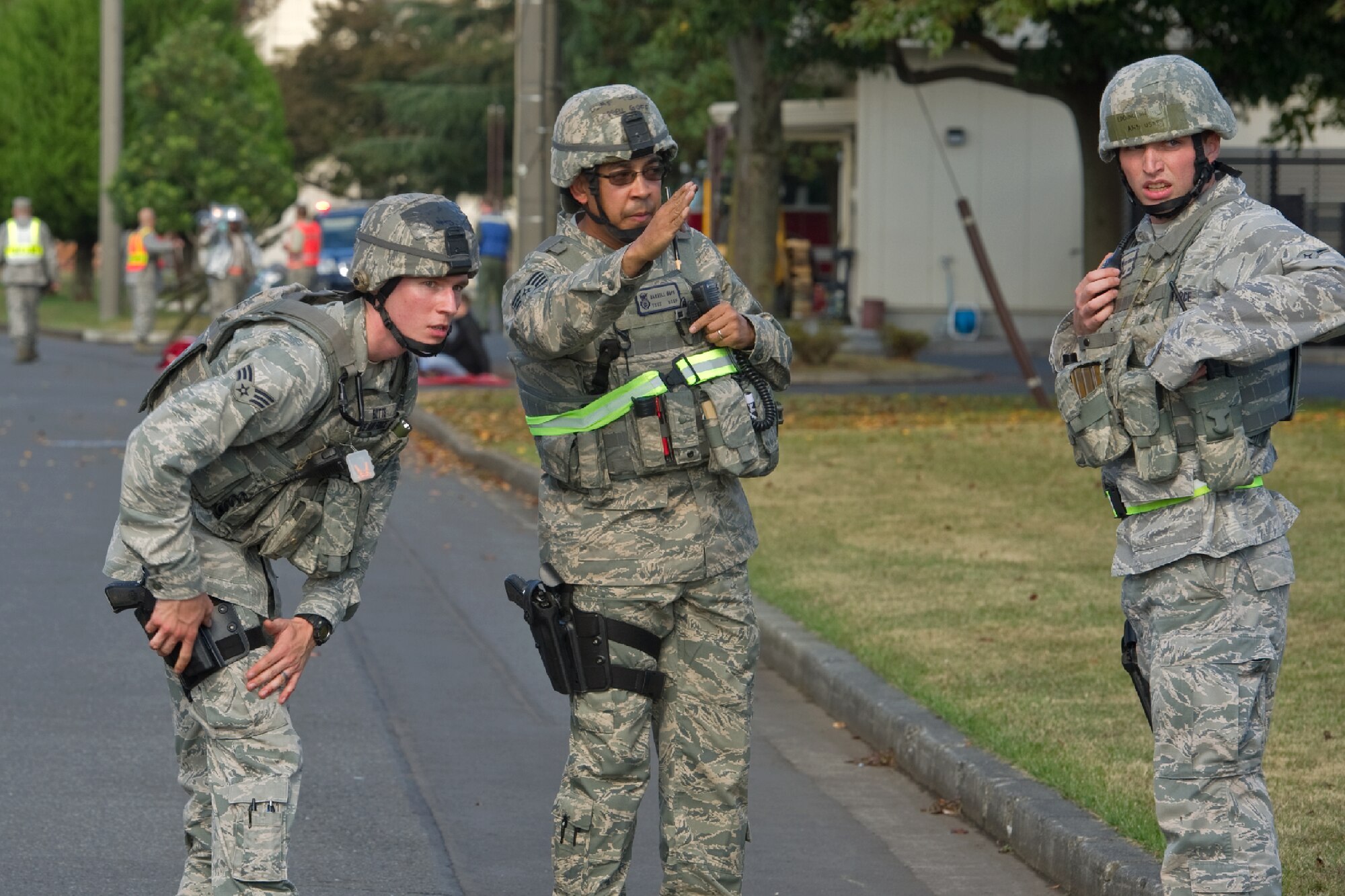 YOKOTA AIR BASE, Japan -- Tech. Sgt. Carrell Goff (center), 374th Security Forces Squadron military working dog handler, provides guidance on how to secure the outside of a facility to Senior Airman James Butts (left) and Airman Bryce Eddington (right), both 374th SFS patrolmen, during an active shooter scenario at Yokota Air Base, Japan, Nov. 7, 2011. Yokota is participating in a week-long exercise to maintain operational readiness capabilities. (U.S. Air Force photo/Osakabe Yasuo)