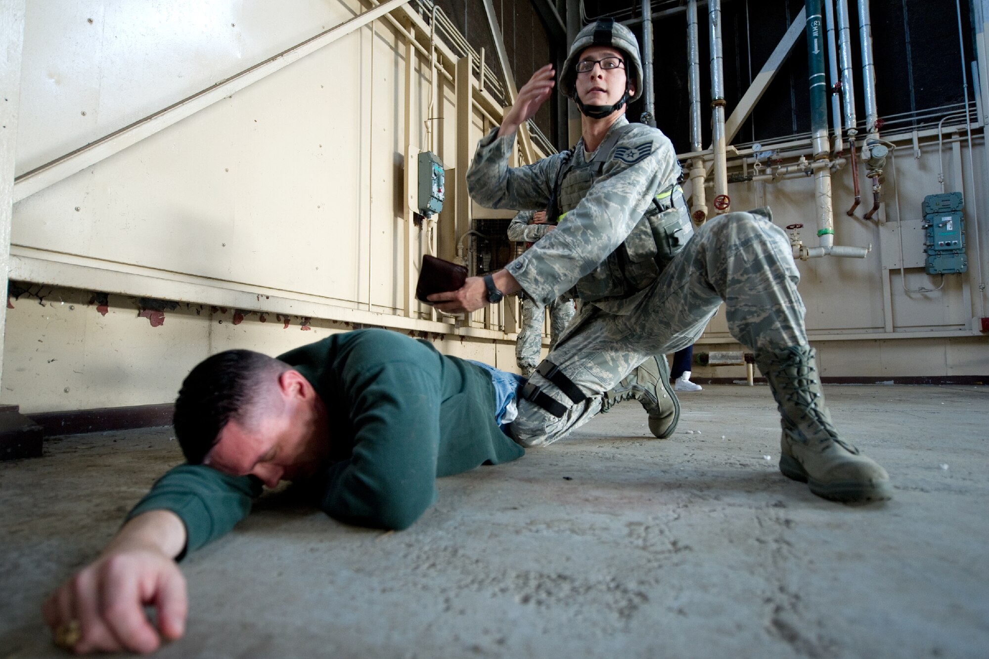 YOKOTA AIR BASE, Japan -- Staff Sgt. Rafael Quiroz, 374th Security Forces Squadron patrolman, searches a role player during an active shooter scenario at Yokota Air Base, Japan, Nov. 7, 2011. Yokota is participating in a week-long exercise to maintain operational readiness capabilities. (U.S. Air Force photo/Osakabe Yasuo)