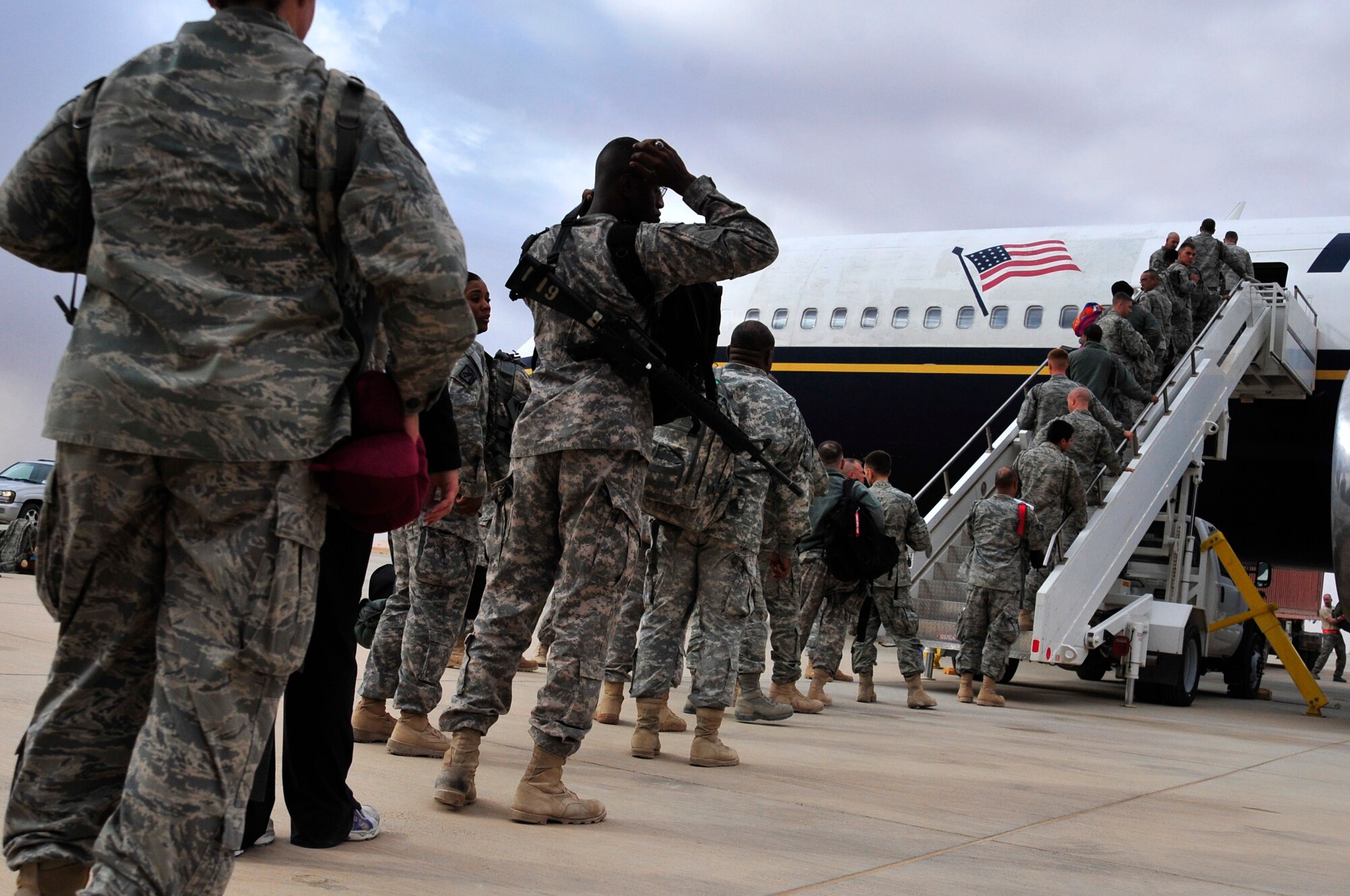 U.S. service members board an aircraft on the Al Asad Air Base flight line Nov. 1, 2011, that will bring them back to the U.S. The group was deployed in support of Operation New Dawn and helped create a more stable, sovereign and self-reliant Iraq. The U.S. military is on track to honor its commitment to the U.S.-Iraq Security Agreement and redeploy the remaining 33,000 troops by Dec. 31, 2011.  At the height of the surge in 2007, there were 165,000 U.S. troops in Iraq. This drawdown is one of the largest military operations since World War II.  (U.S. Air Force photo/Master Sgt. Cecilio Ricardo)