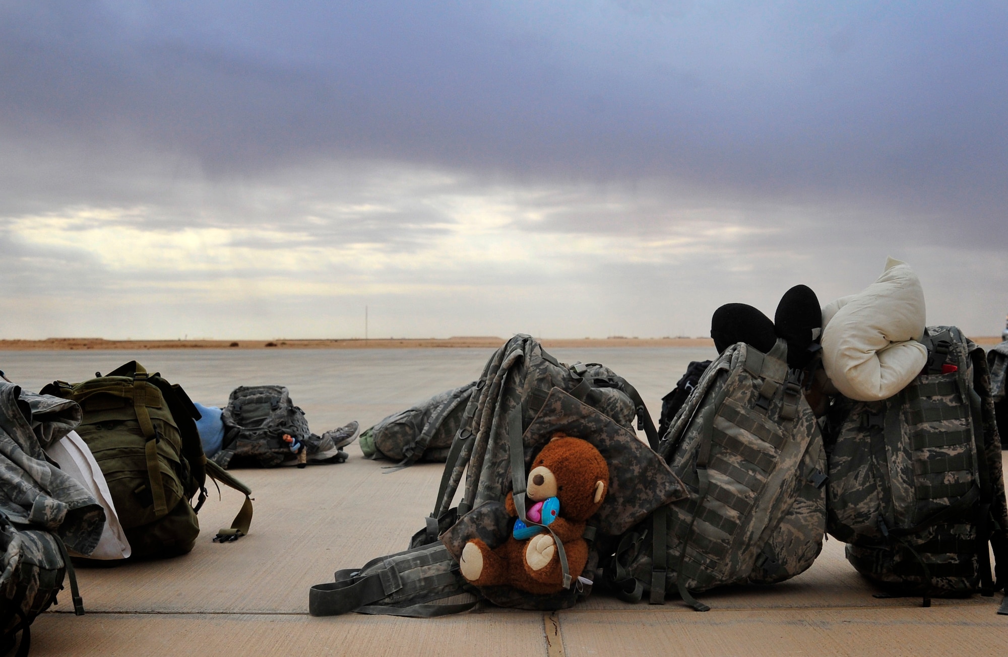 Backpacks belonging to U.S. service members sit on the flight line at Al Asad Air Base, Iraq, Nov. 1, 2011, while the troops load luggage onto the aircraft that will bring them back to the U.S. They service members were deployed in support of Operation New Dawn and helped create a more stable, sovereign and self-reliant Iraq. The U.S. military is on track to honor its commitment to the U.S.-Iraq Security Agreement and redeploy the remaining 33,000 troops by Dec. 31, 2011.  At the height of the surge in 2007, there were 165,000 U.S. troops in Iraq. This drawdown is one of the largest military operations since World War II.  (U.S. Air Force photo/Master Sgt. Cecilio Ricardo)