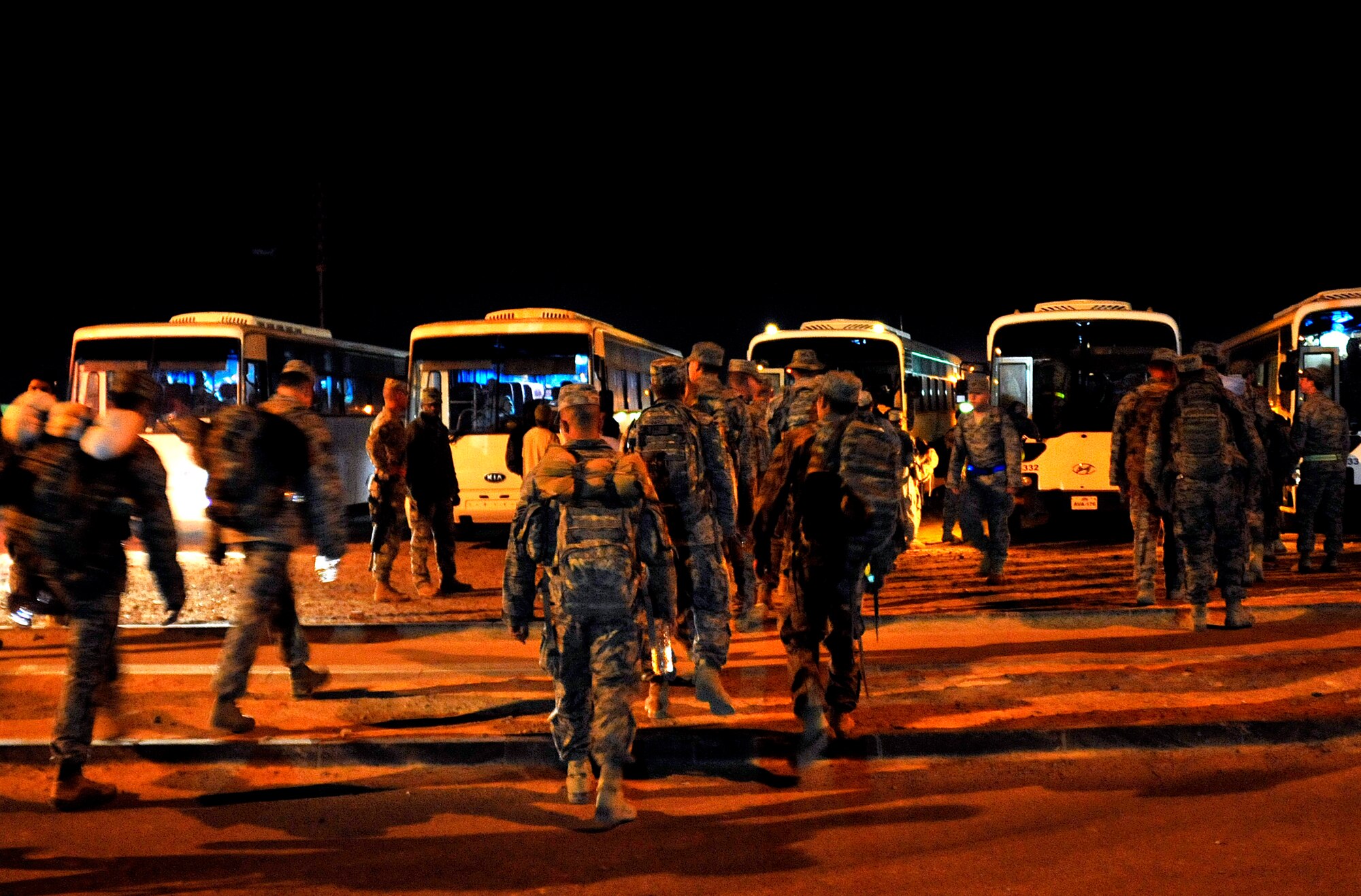 U.S. service members gather early in the morning on Nov. 1, 2011, onto buses that will bring them to the Al Asad Air Base Passenger Terminal in Iraq to begin their journey to the U.S.  The group was deployed in support of Operation New Dawn and helped create a more stable, sovereign and self-reliant Iraq. The U.S. military is on track to honor its commitment to the U.S.-Iraq Security Agreement and redeploy the remaining 33,000 troops by Dec. 31, 2011. At the height of the surge in 2007, there were 165,000 U.S. troops in Iraq. This drawdown is one of the largest military operations since World War II.  (U.S. Air Force photo/Master Sgt. Cecilio Ricardo)