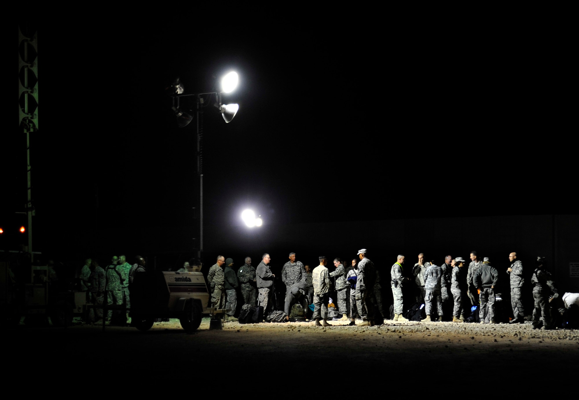 U.S. service members gather early in the morning on Nov. 1, 2011, near their tents in Iraq to begin their journey to the U.S.  The group was deployed in support of Operation New Dawn and helped create a more stable, sovereign and self-reliant Iraq. The U.S. military is on track to honor its commitment to the U.S.-Iraq Security Agreement and redeploy the remaining 33,000 troops by Dec. 31, 2011. At the height of the surge in 2007, there were 165,000 U.S. troops in Iraq. This drawdown is one of the largest military operations since World War II.  (U.S. Air Force photo/Master Sgt. Cecilio Ricardo)