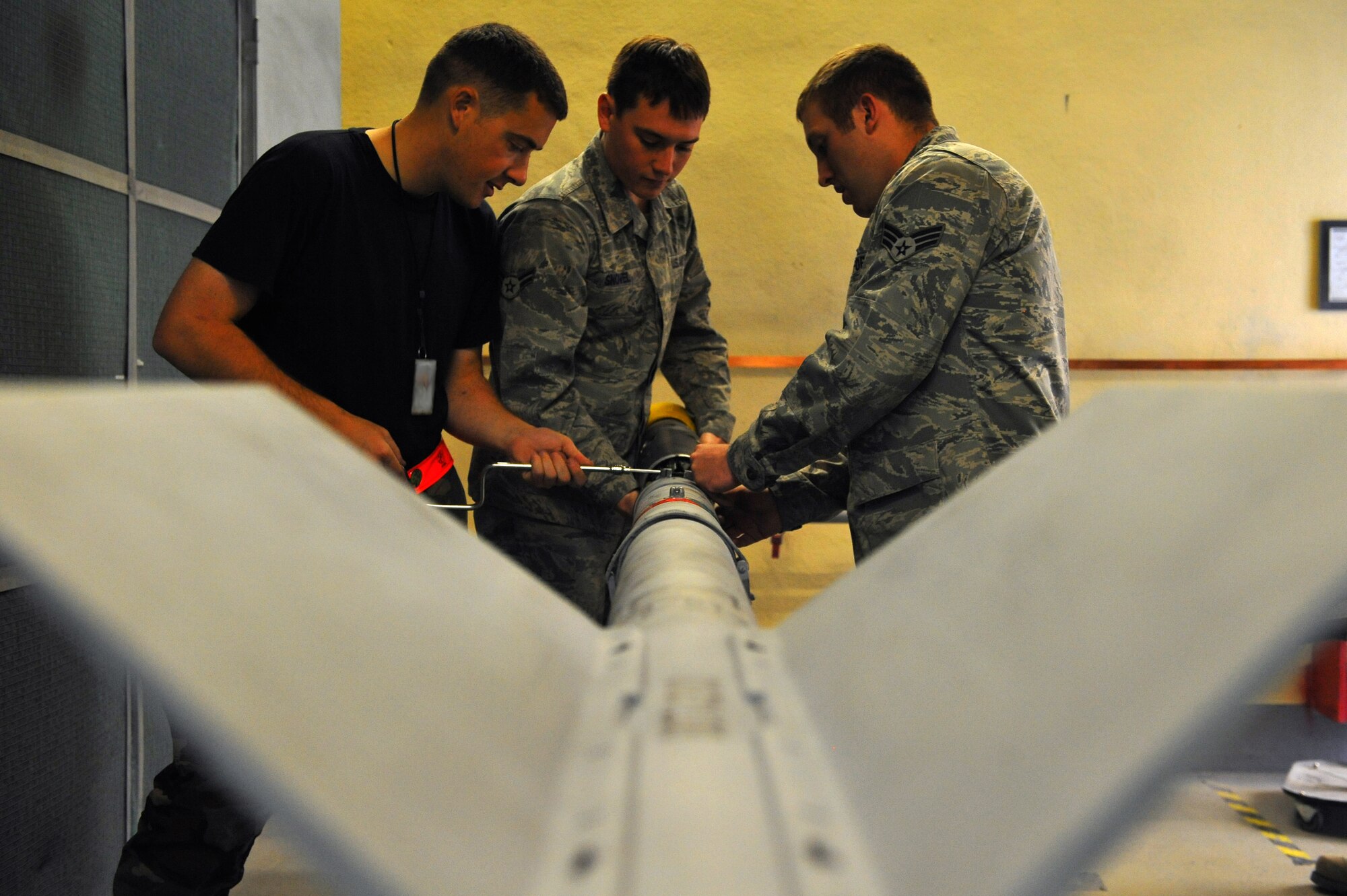 SPANGDAHLEM AIR BASE, Germany – Staff Sgt. Scott Cooper, Airman 1st Class Travis Snovel and Senior Airman Daniel Chapman, 52nd Equipment Maintenance Squadron precision-guided munitions maintenance crew members, replace the head of a missile inside the munitions maintenance shop here Oct. 27. The 52nd EMS tests every munition on base after 20 flights or after 180 days to guarantee mission surety and provide combat power to U.S. European Command. (U.S. Air Force photo/Airman 1st Class Dillon Davis)