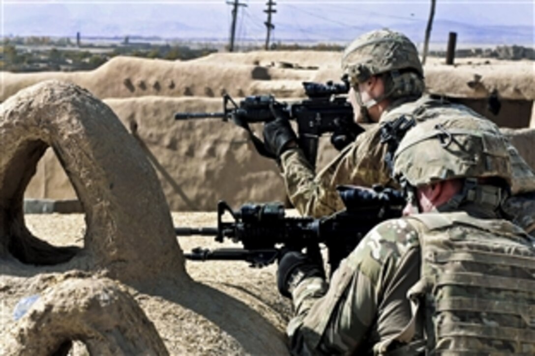 U.S. Army Spc. Matthew Newcomb, left, and Pfc. Brandon Hobgood scan their sectors from a rooftop vantage point in Ghazni province, Afghanistan, Oct. 31, 2011. Newcomb and Hobgood are assigned to the 1st Infantry Division's Company D, 2nd Battalion, 2nd Infantry Regiment, 3rd Brigade Combat Team. They are part of a humanitarian assistance mission led by Afghan National Army elements, distributing school supplies, radios and blankets to children and villagers.