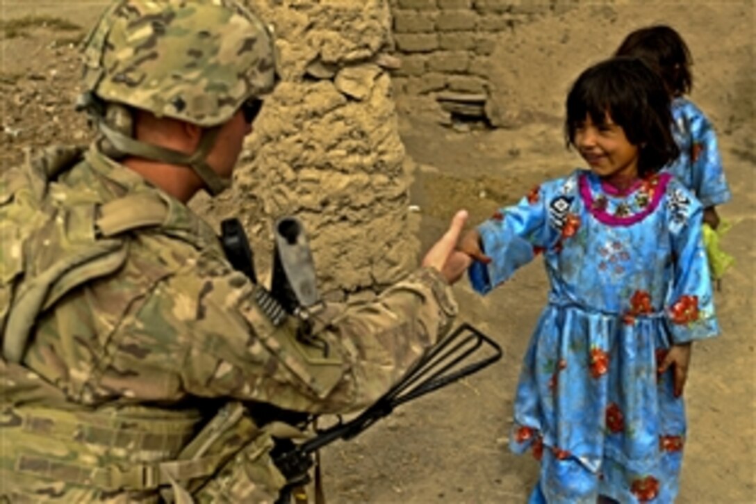 U.S. Army Pfc. Richard Mills greets a shy Afghan girl in Shinkai, Afghanistan, Nov. 7, 2011. Mills is a rifleman assigned to Provincial Reconstruction Team Zabul and is deployed from Company C, 182nd Infantry Division, Massachusetts National Guard.
