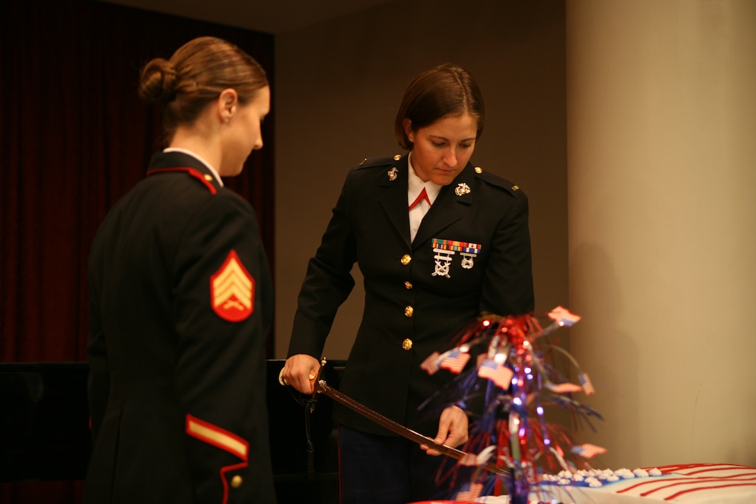 2nd Lt. Lindsay Thorstenson cuts the Marine Corps birthday cake with the traditional Mameluke sword while Brenlie Wilson, a former sergeant and the youngest present member of the Molly Marine Chapter LA-1 waits to receive the piece of cake and pass it on to the oldest Marine present. (Photo by Pfc. Jessica DeRose)